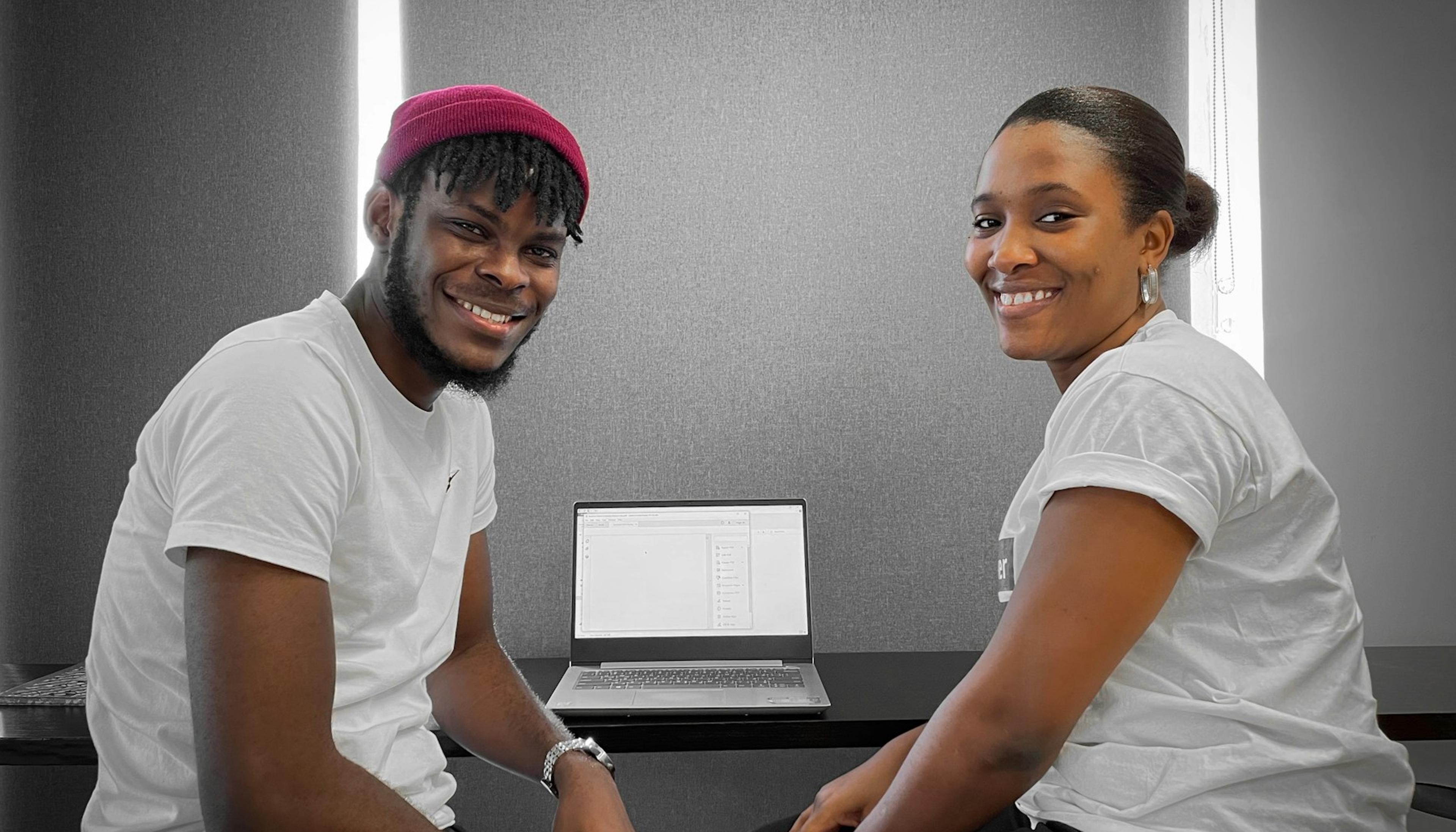 Two young professionals working together on a laptop