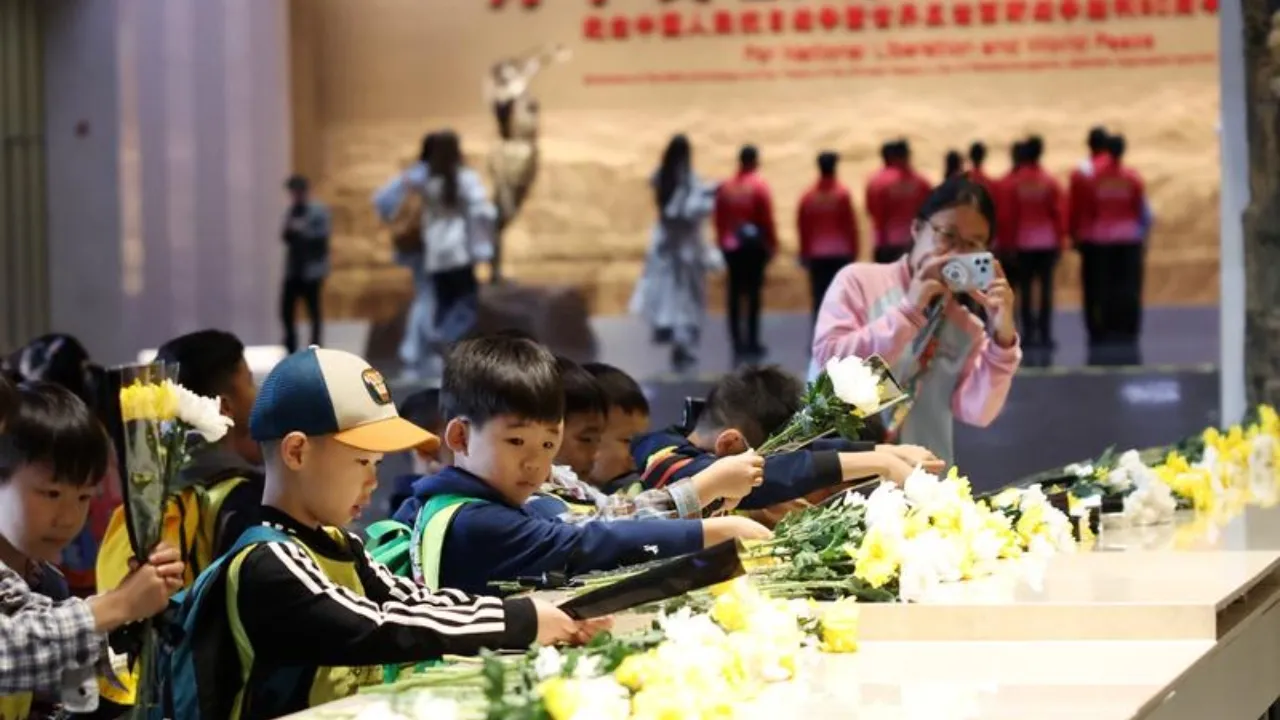 Bambini depongono fiori durante le commemorazioni al museo di Pechino (Foto agenzia Xinhua)