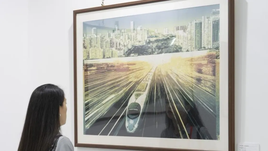 Una donna osserva un dipinto esposto durante la prima settimana della cultura e dell’arte ferroviaria di Pechino. Foto Cai Yang/Xinhua