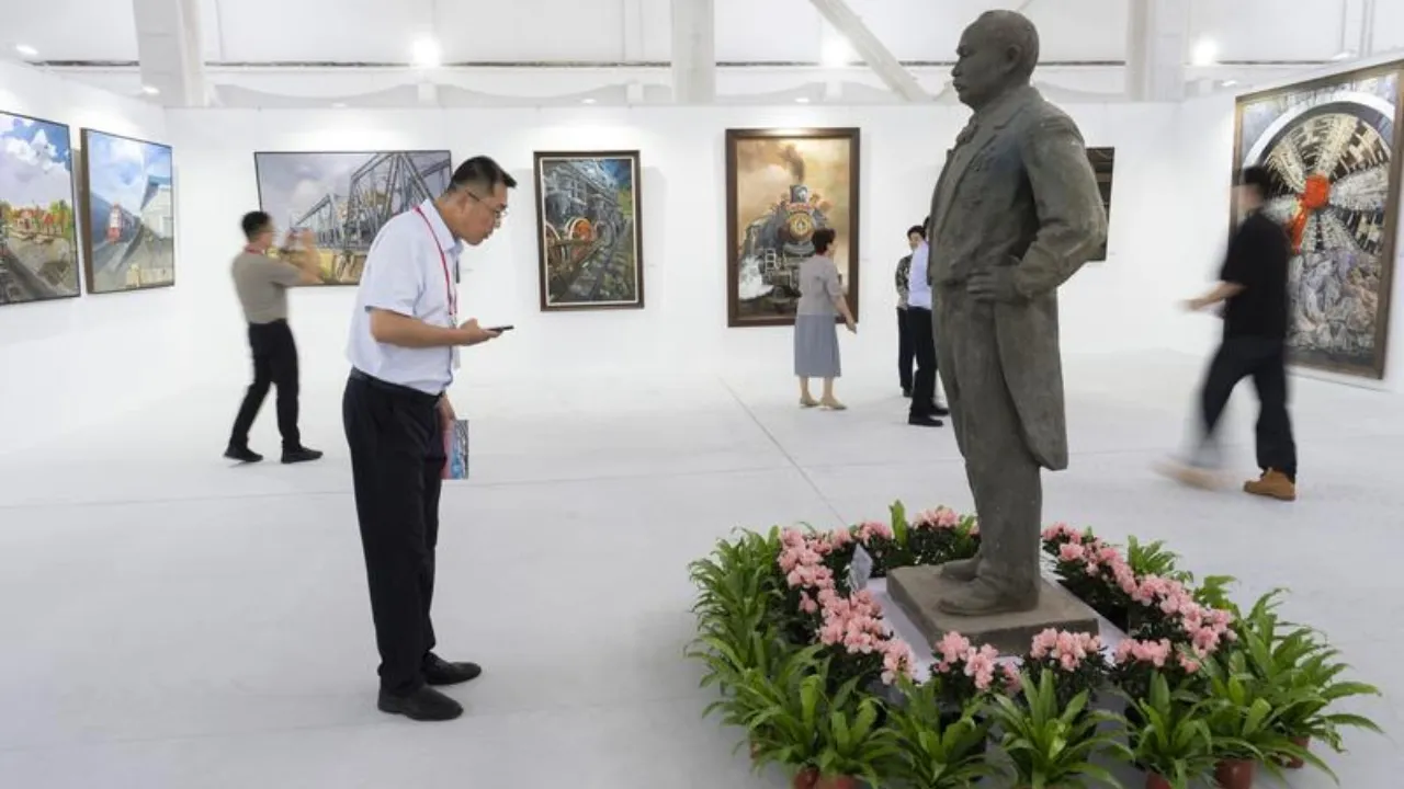 Un visitatore davanti alla scultura dedicata a Zhan Tianyou, figura centrale nella storia delle ferrovie cinesi, nel parco CRRC Erqi di Pechino. Foto Cai Yang/Xinhua
