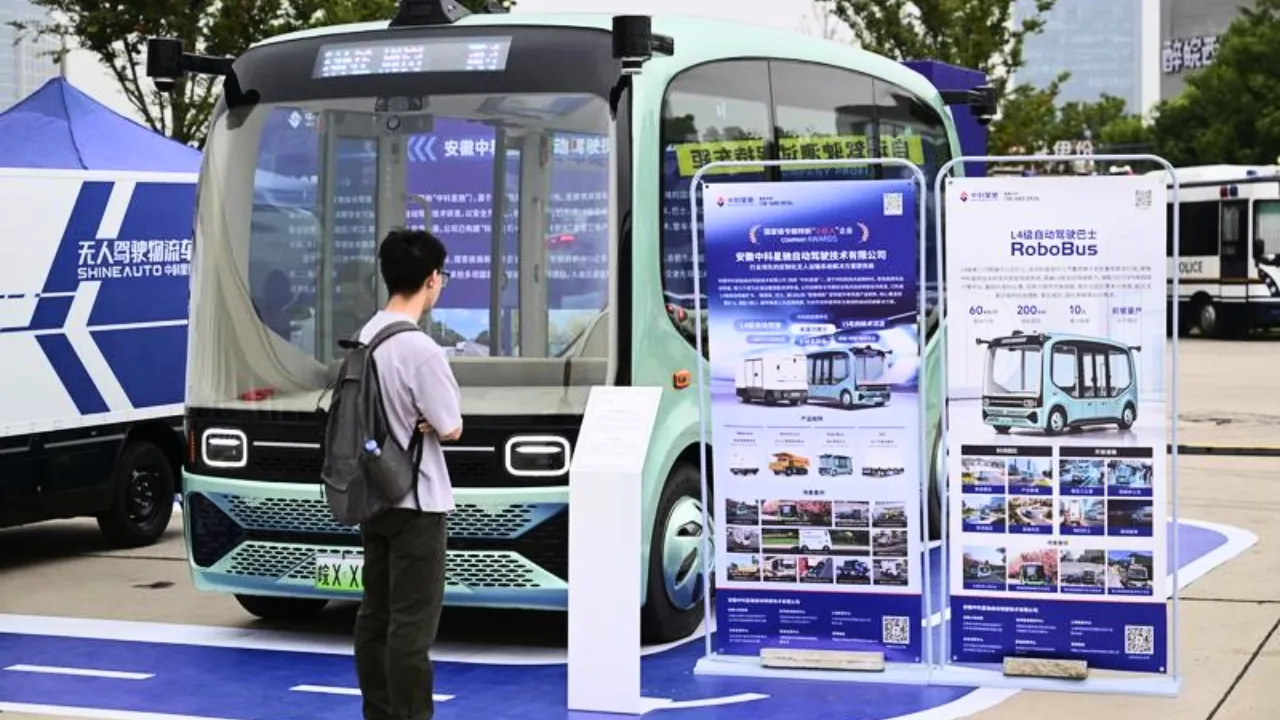 Hefei, 20 settembre 2026. Un visitatore osserva un autobus a guida autonoma esposto nel parco Luogang. Foto Xinhua/Zhou Mu.