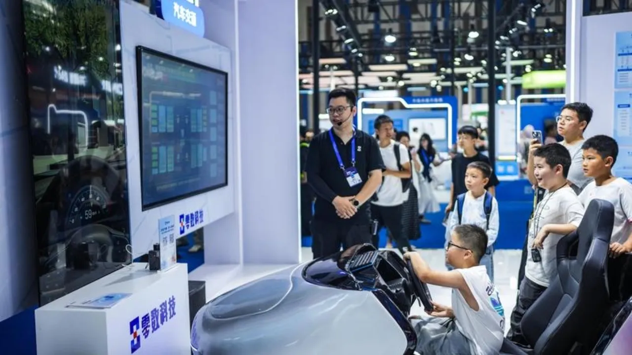 Bambini provano un simulatore di guida intelligente alla fiera di Guiyang. Foto Xinhua/Tao Liang