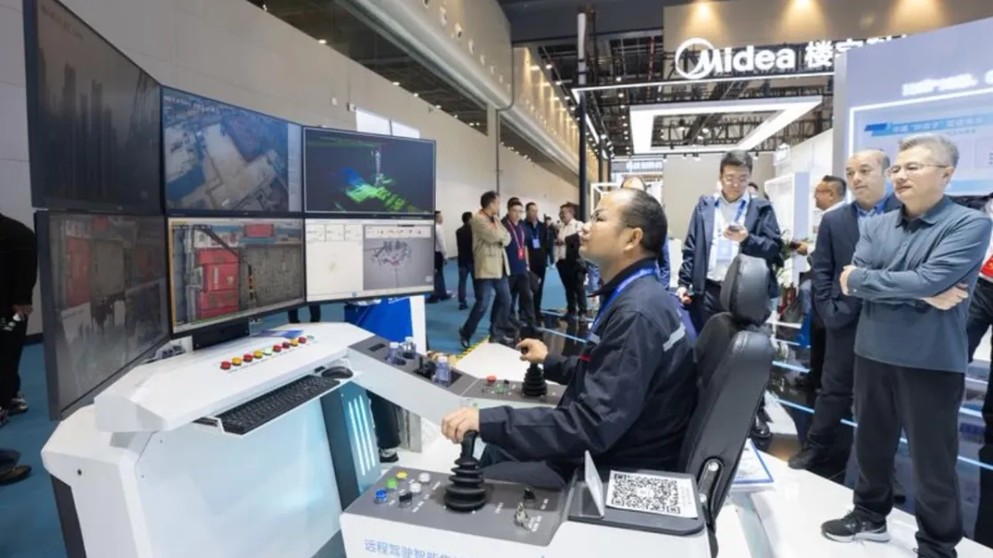 Un operatore controlla a distanza una gru a torre intelligente durante la fiera dell'edilizia di Wuhan (Foto agenzia Xinhua)