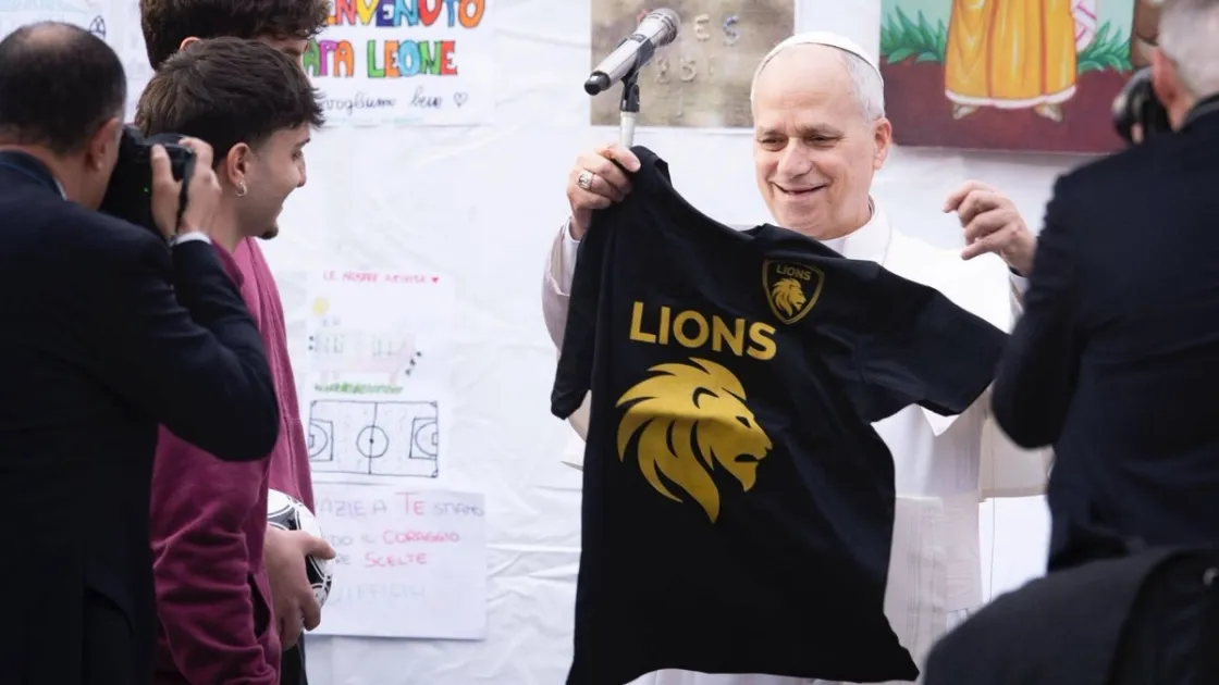 Il papa al Quarticciolo mentre riceve la maglia dai ragazzi del percorso “Magis” (Credit: Diocesi di Roma)