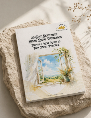 Luna Mantra 30-Day September Lunar Living Workbook resting on a pale stone slab in soft sunlight, styled with a dried flower sprig and gentle shadows, showing the watercolor open-window cover and new moon to new moon practice subtitle.