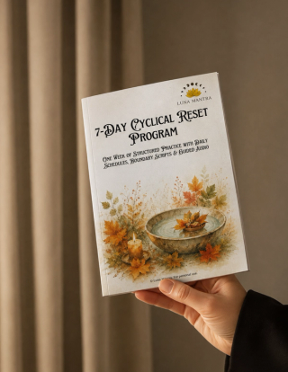 Luna Mantra 7-Day Cyclical Reset Program for September lifestyle mockup with a hand holding the printed booklet in front of soft pleated beige curtains, showing the watercolour bowl and candle cover art in warm neutral light.