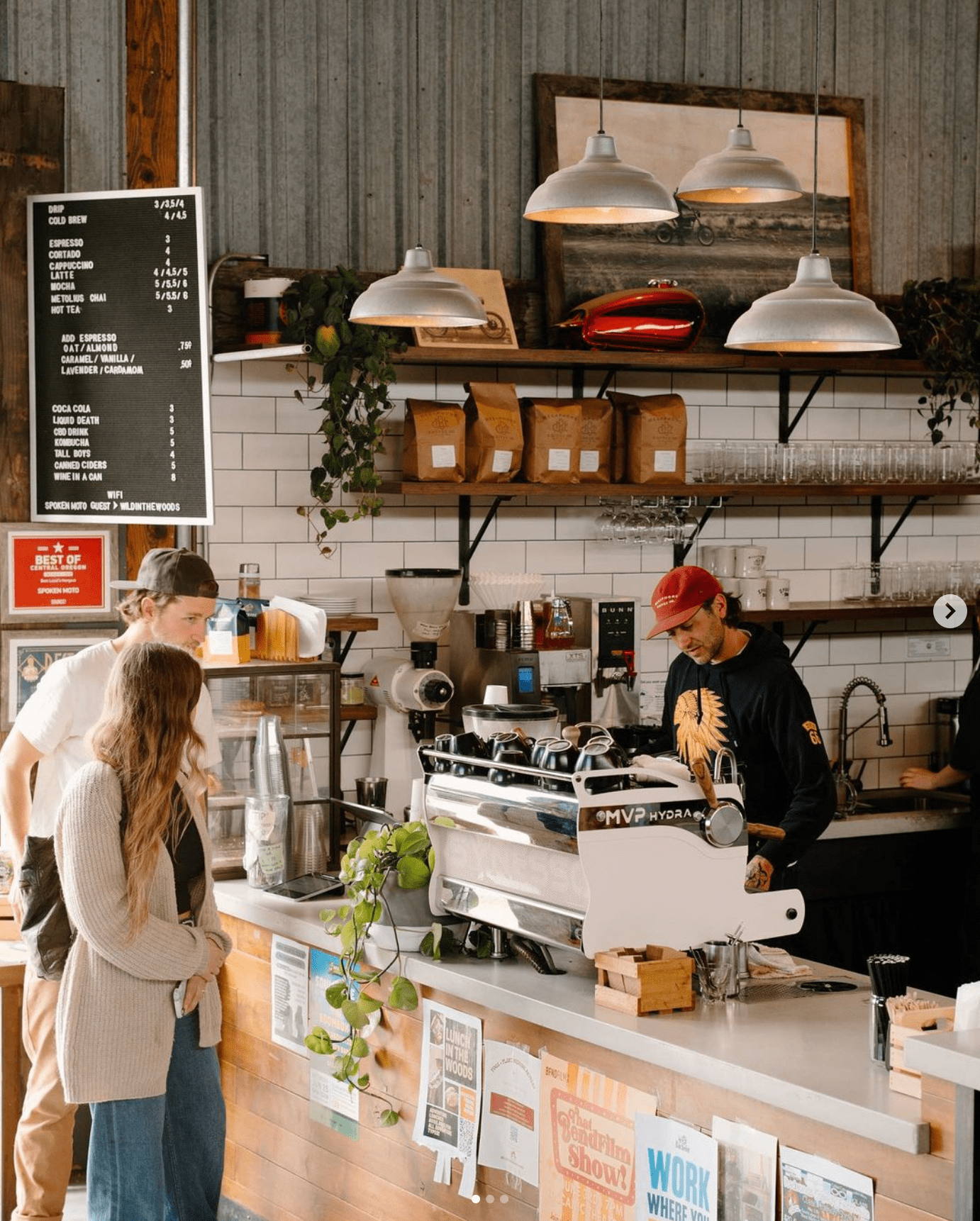 A barista serving patrons at Spoken Moto coffee shop.