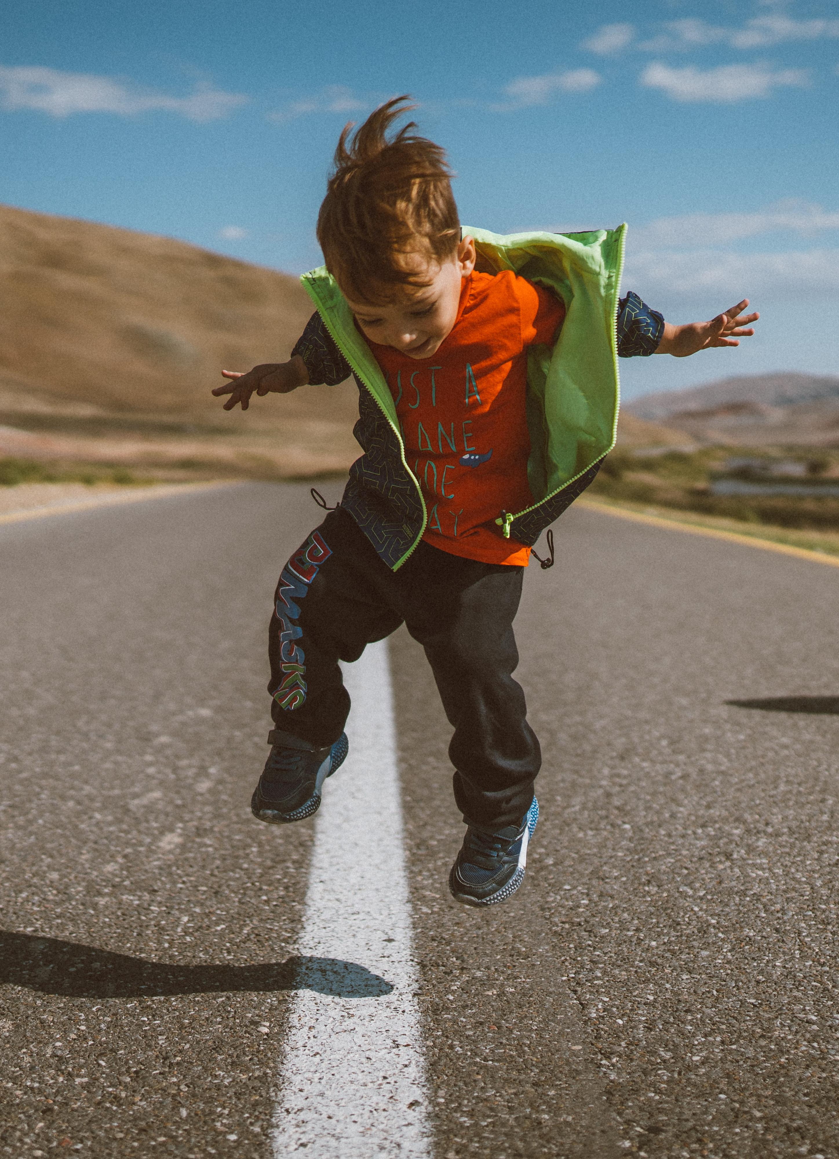 Kid jumping over a streetline