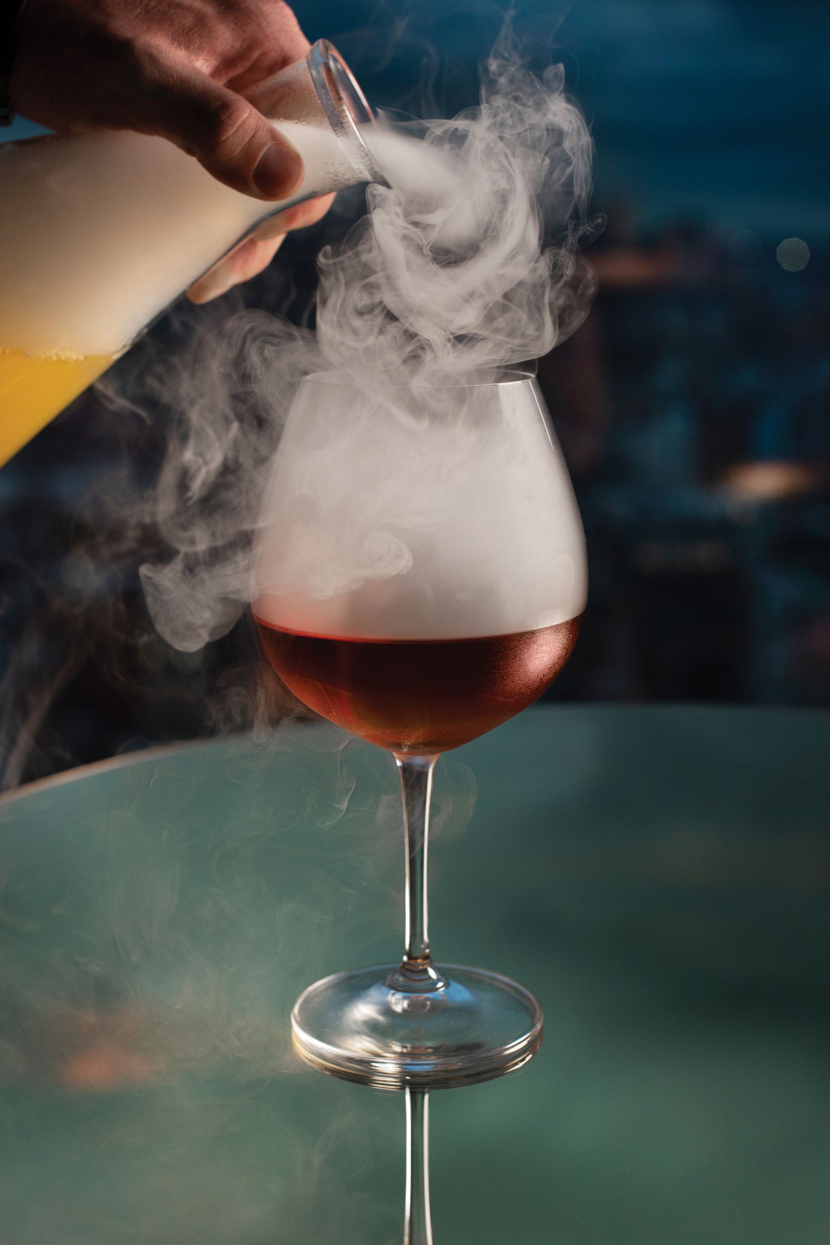 mixologist pouring cocktail