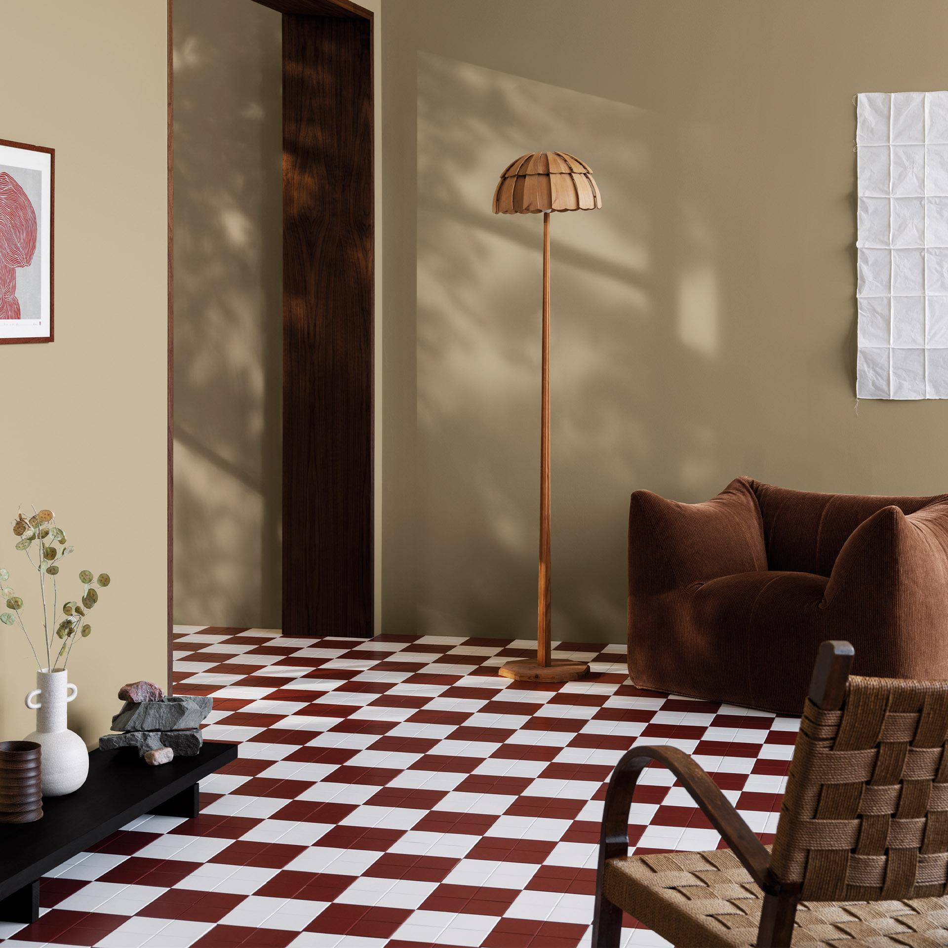Stylish modern living room with olive green and beige walls, a red and white checkered floor, a brown armchair, and a wooden floor lamp.