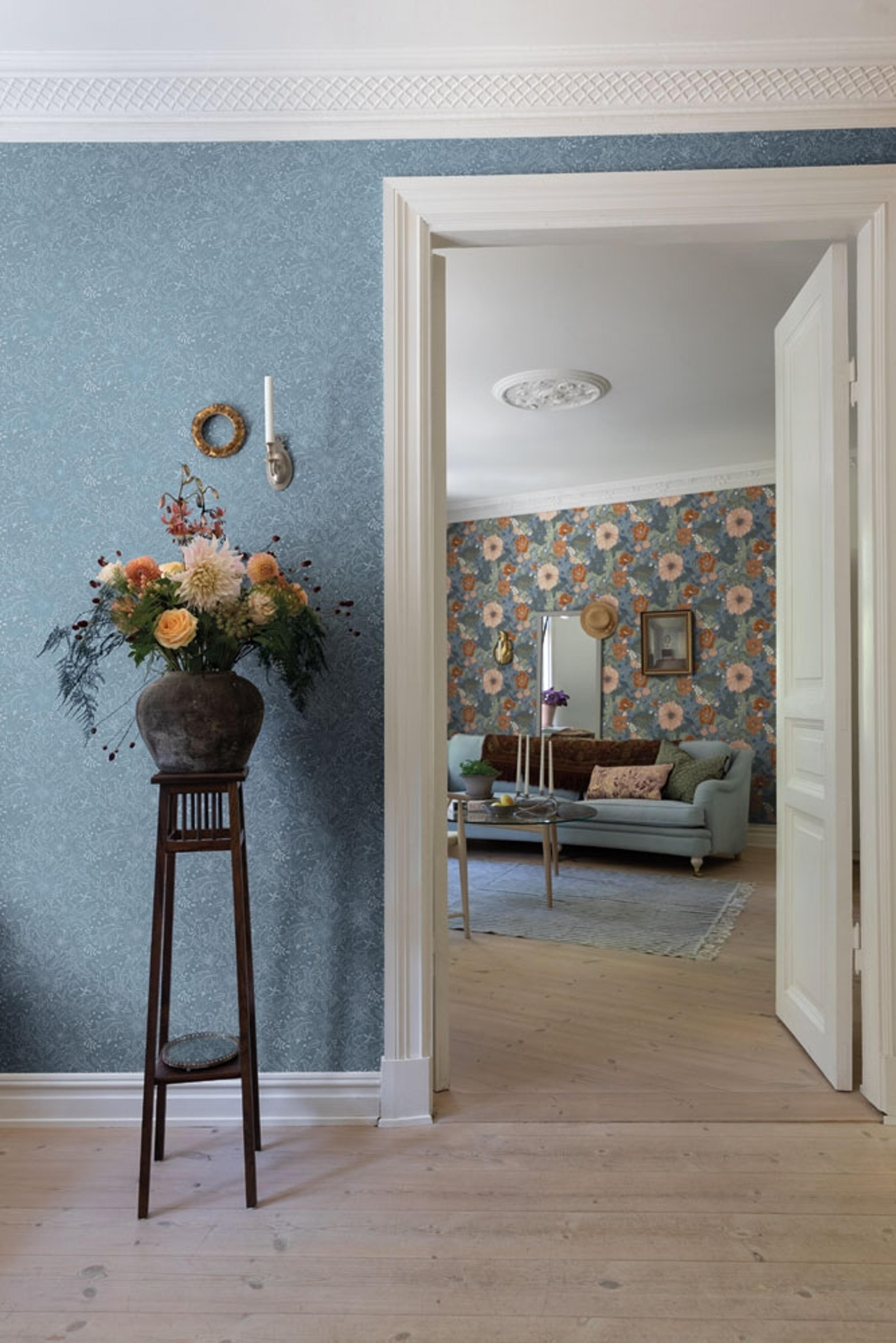 Wilma tapet med blommigt mönster i blå. Från kollektionen Ängås. Nonwoven-material med rak passning.