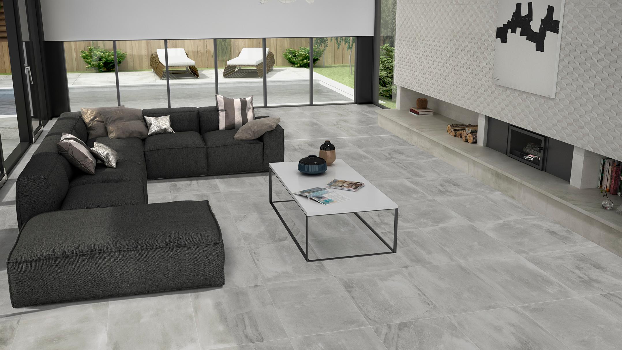 Modern living room with a dark gray sectional sofa, light gray marble-look floor tiles, a fireplace, and large windows.