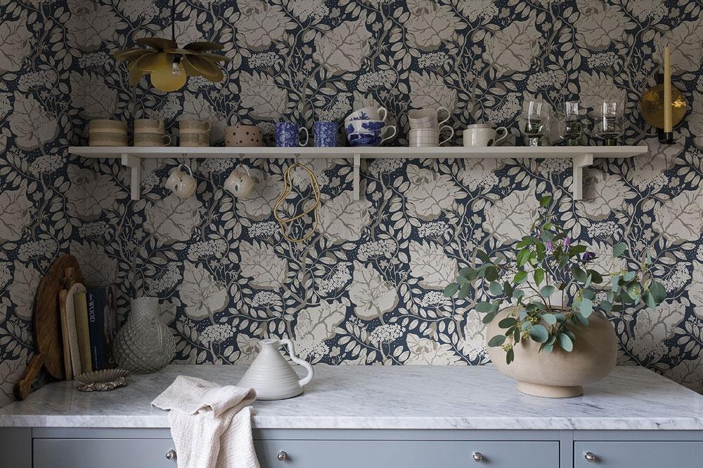 Ulla-Britt tapet med blommigt mönster i grå och blå. Från kollektionen Lina. Nonwoven-material med rak passning.