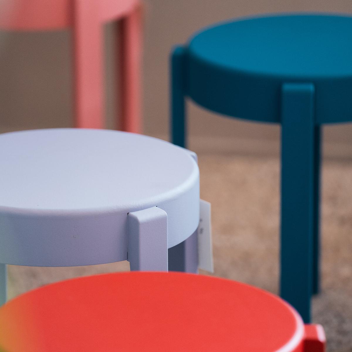 Several colorful round stools, including red, purple, teal, and pink.