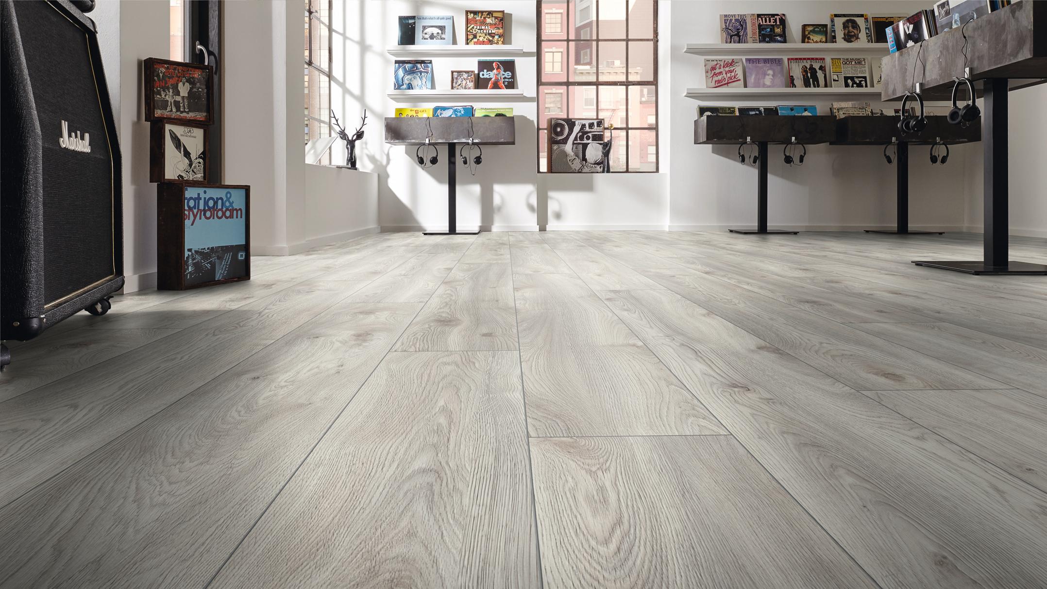 Light grey wood-look plank flooring in a music-themed room with records and an amplifier.