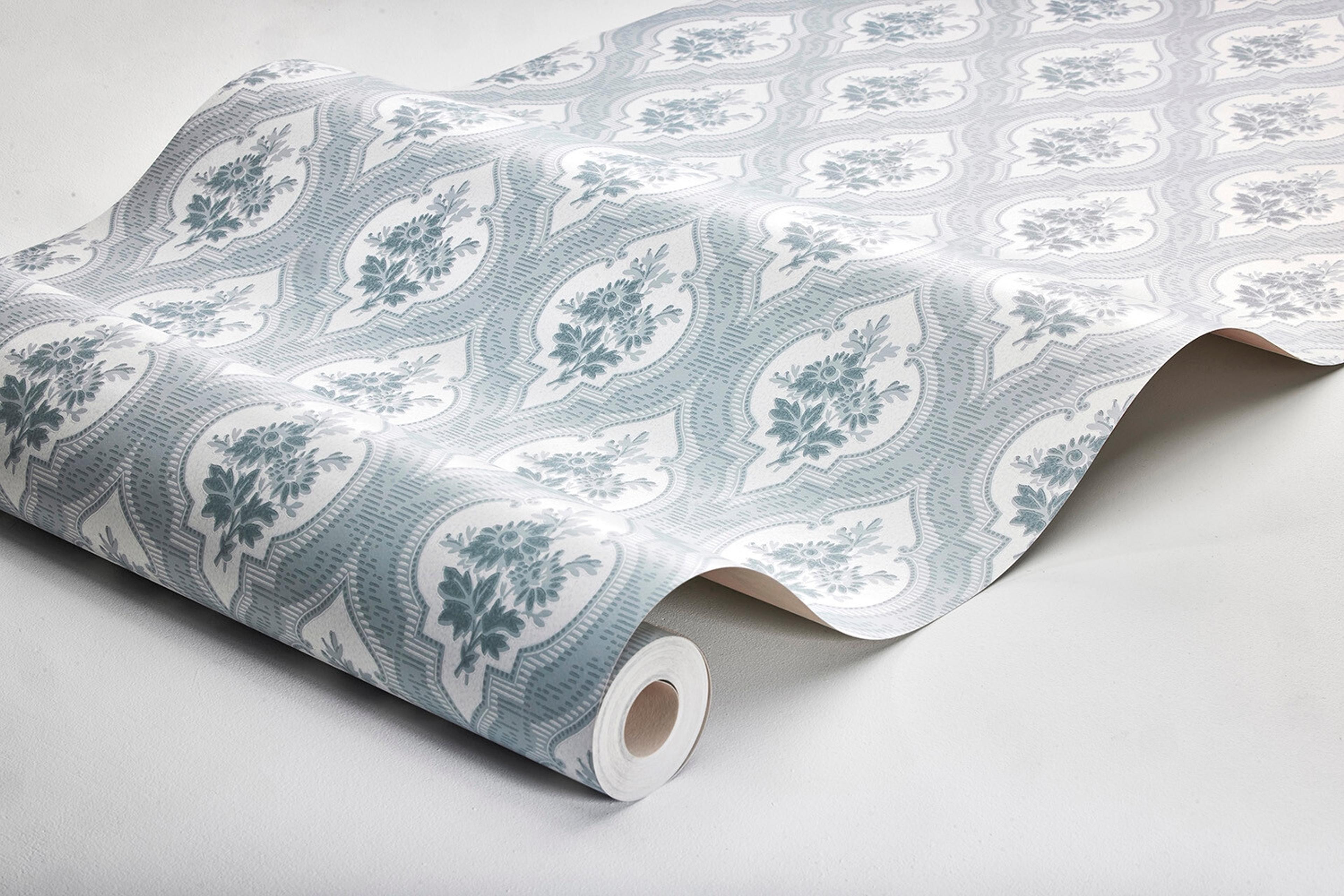 Eternal Flower tapet tapet med blommigt, trellis mönster i blå. Från kollektionen Dreamy Escape. Nonwoven-material med förskjuten passning. Passar i vardagsrum och matsal.