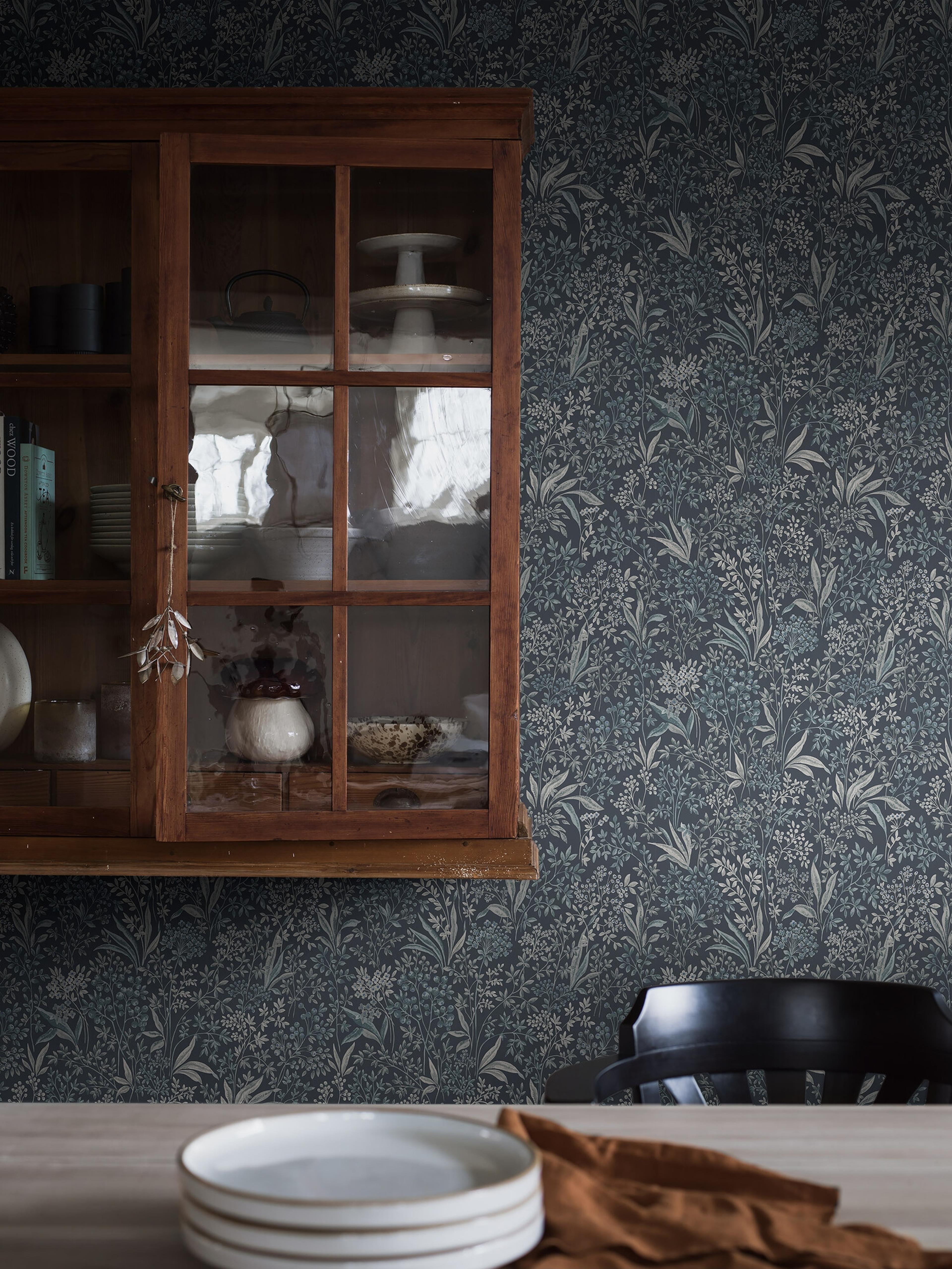 Nocturne slingrande bladverk, mörkblå tapet med botaniskt mönster i blå. Från kollektionen Vårt Arkiv. Nonwoven-material med rak passning.