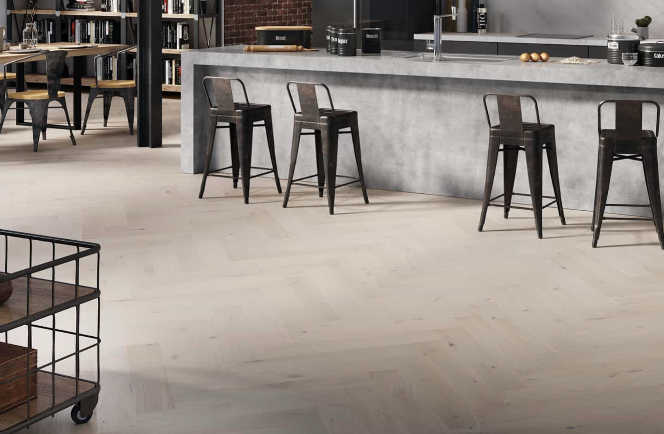 Light herringbone wood floor in an industrial-style kitchen and dining area with a concrete bar.