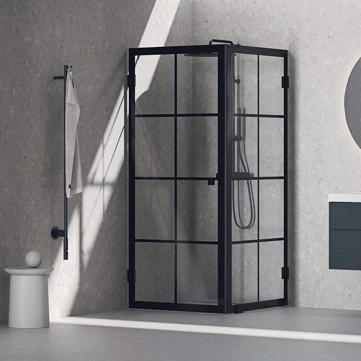 Black grid-framed glass shower enclosure in a modern grey bathroom with sunlight.