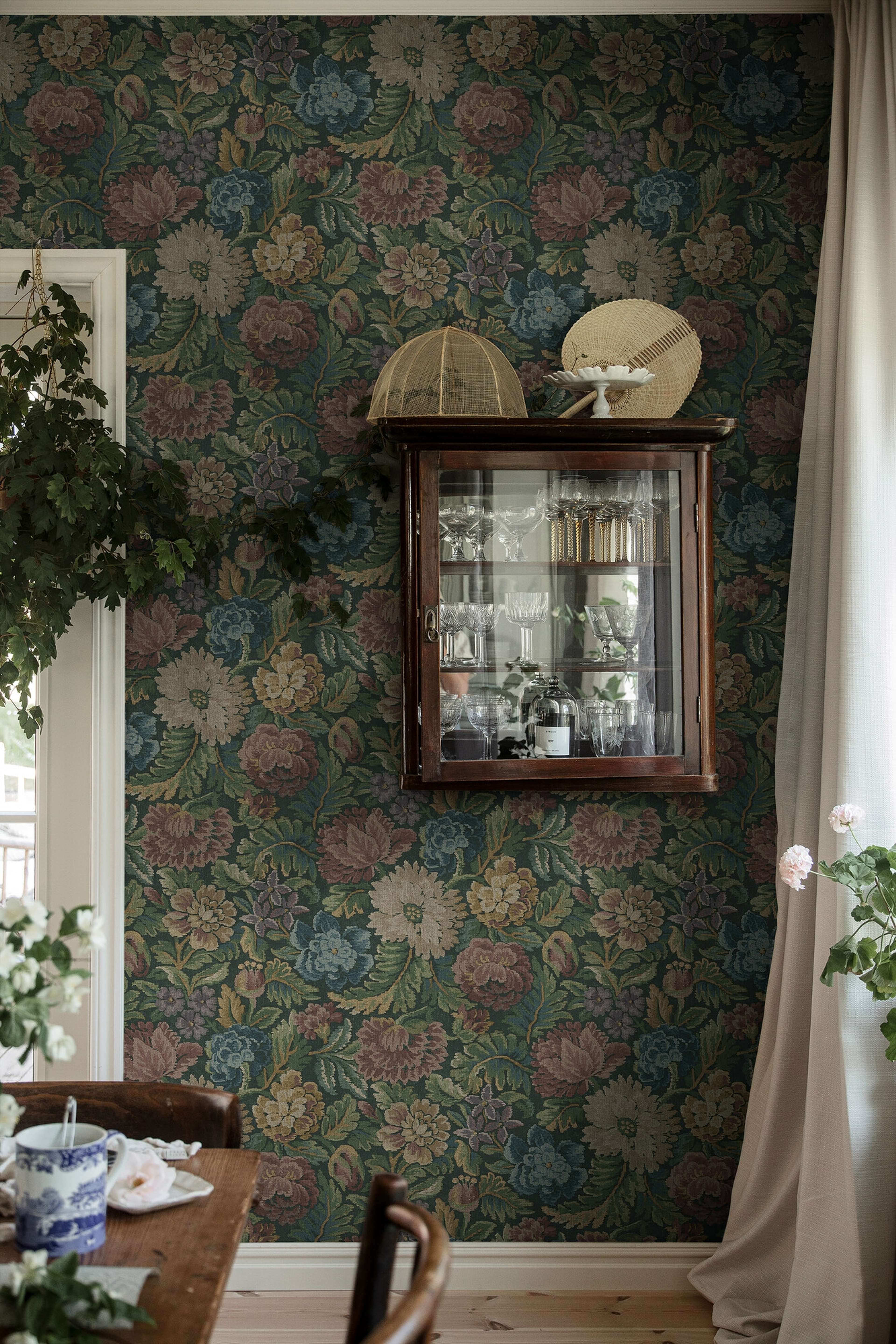 Nightingale Garden Mural mättade toner av grönt, rubinrött tapet med blommigt mönster i röd och grön. Från kollektionen Cottage Garden. Nonwoven-material med rak passning. Passar i vardagsrum, matsal och hall.