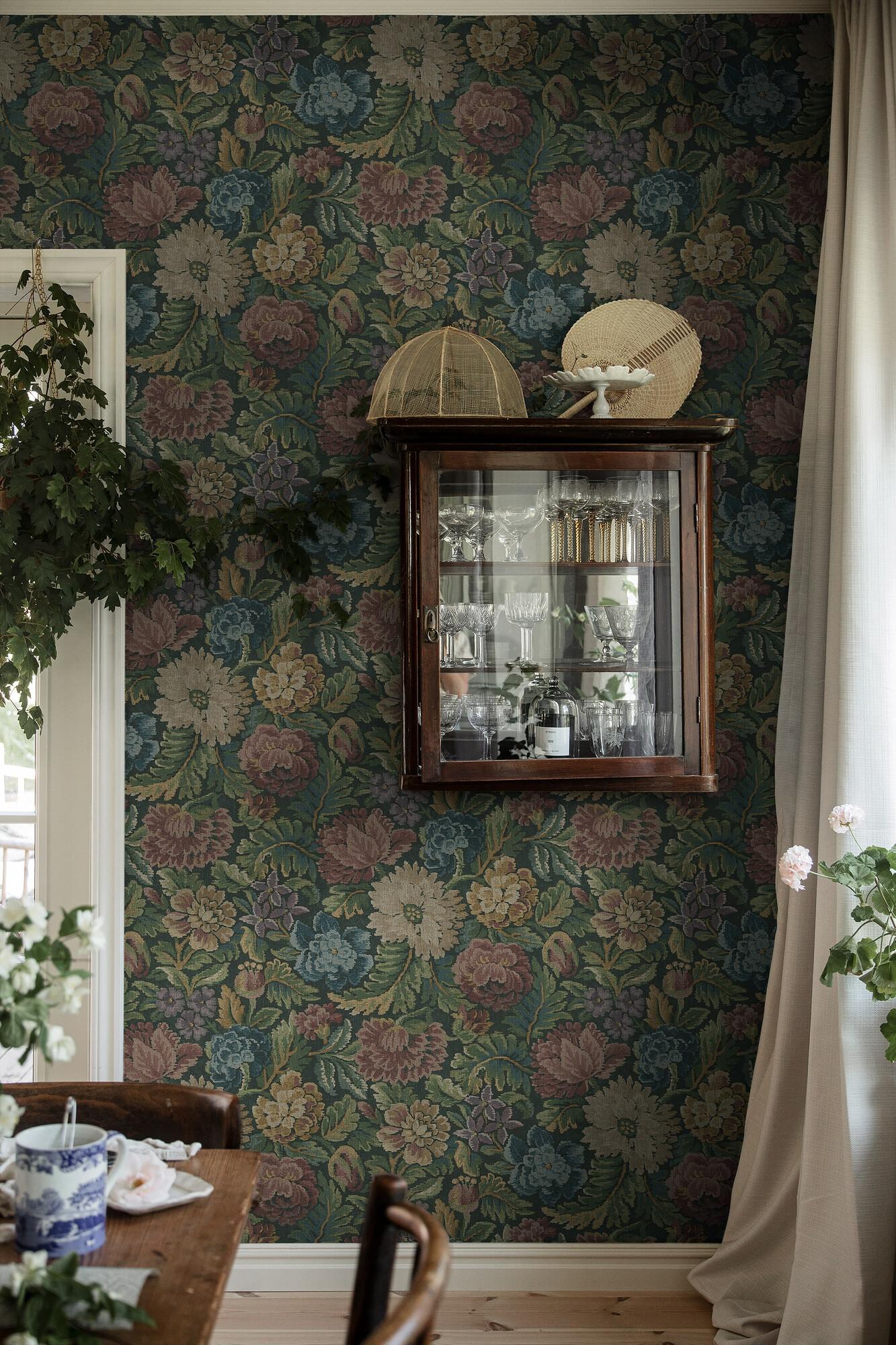 Nightingale Garden Mural mättade toner av grönt, rubinrött tapet med blommigt mönster i röd och grön. Från kollektionen Cottage Garden. Nonwoven-material med rak passning. Passar i vardagsrum, matsal och hall.