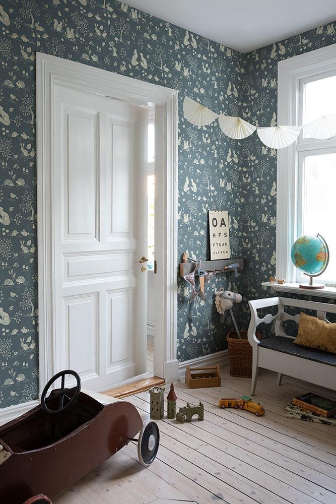 Ivar, blågrön med mönster av träd och djur tapet med djur mönster i blå. Från kollektionen Grönhaga. Nonwoven-material med förskjuten passning. Lek-stil. Passar i barnrum.