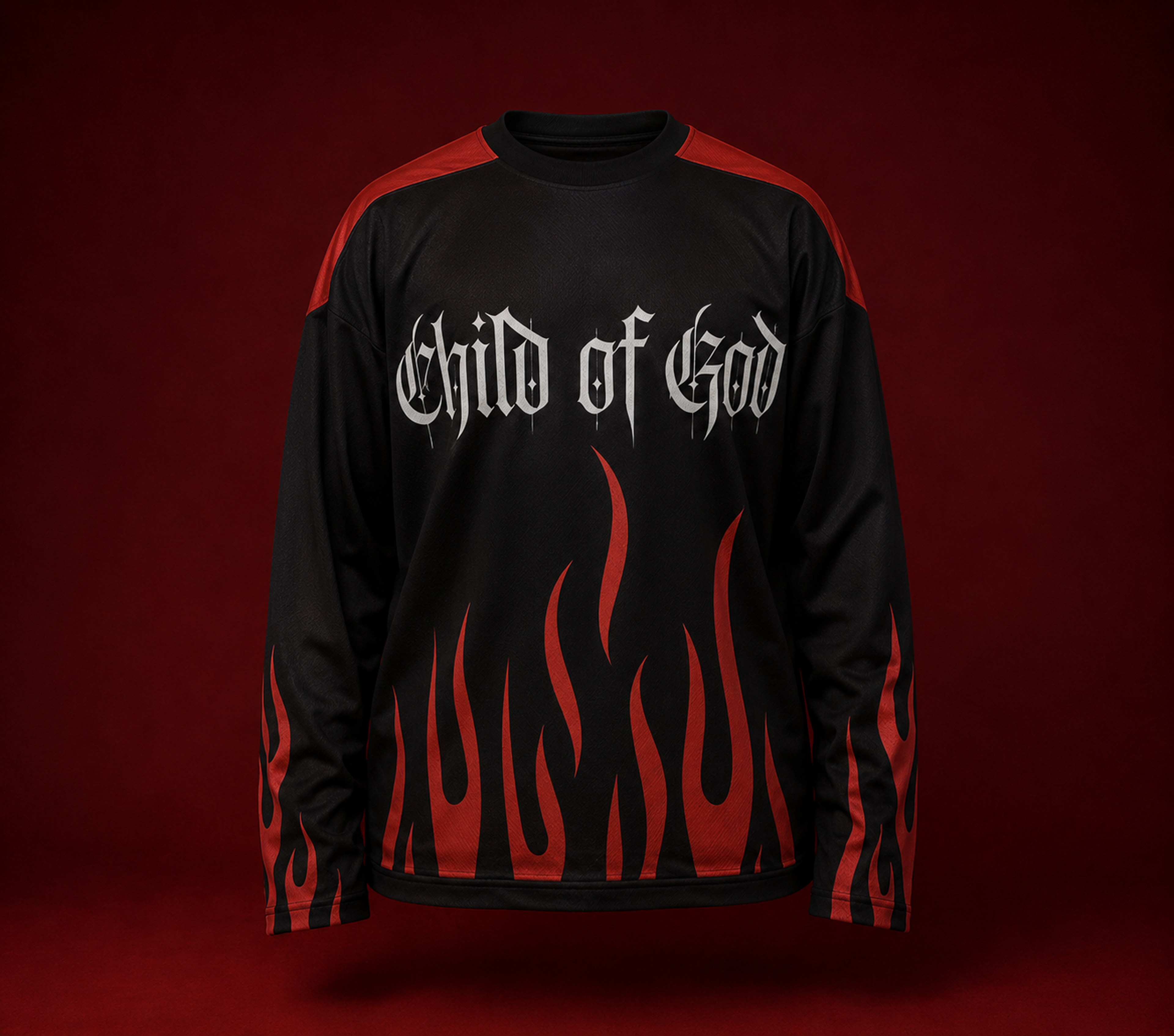 Black long-sleeve jersey featuring gothic “Child of God” lettering with bold red flame graphics across the front and sleeves, displayed against a deep red luxury studio background.
