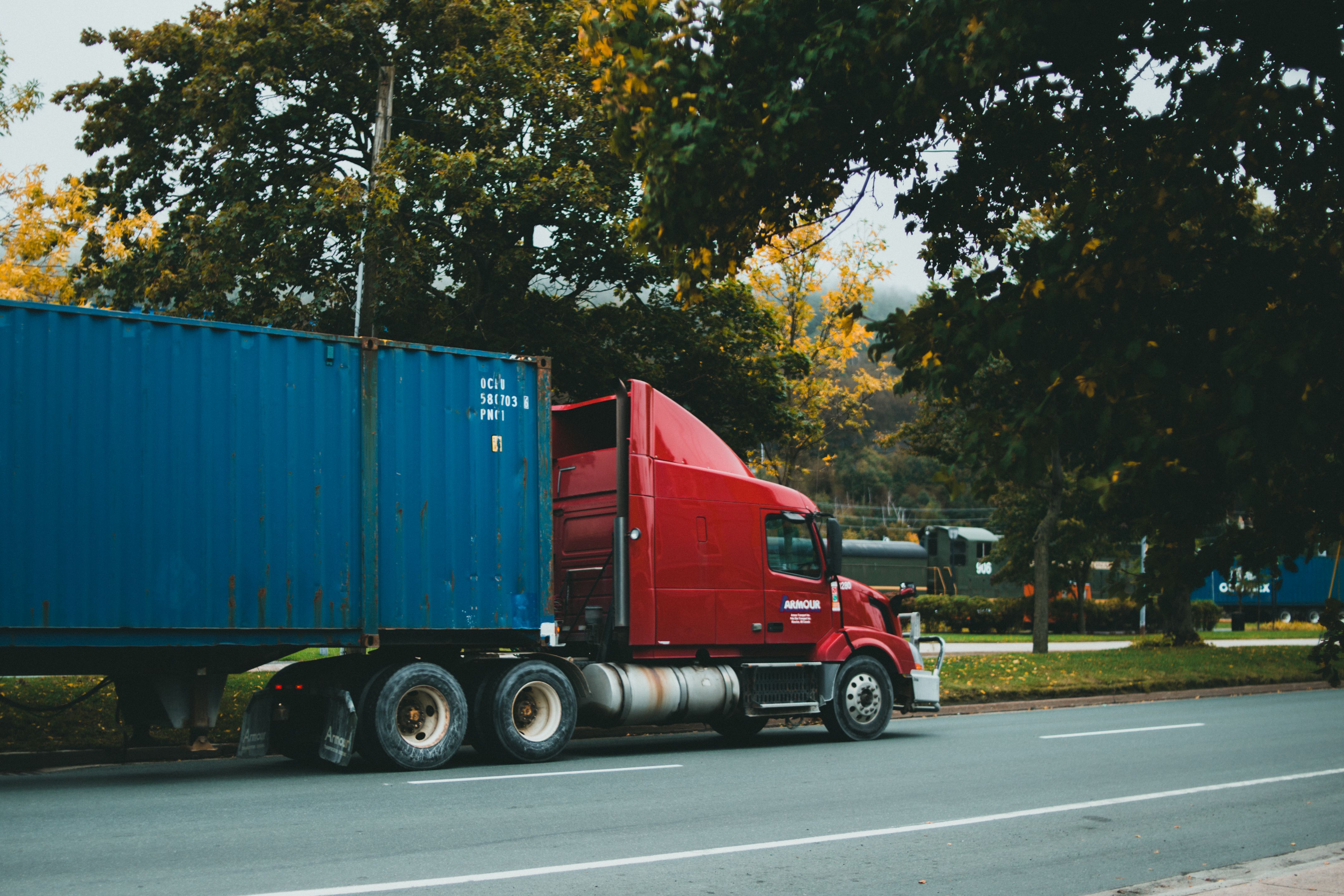Red semi-truck hauling a freight broker container on a highway, symbolizing new Supreme Court ruling for truck accidents.