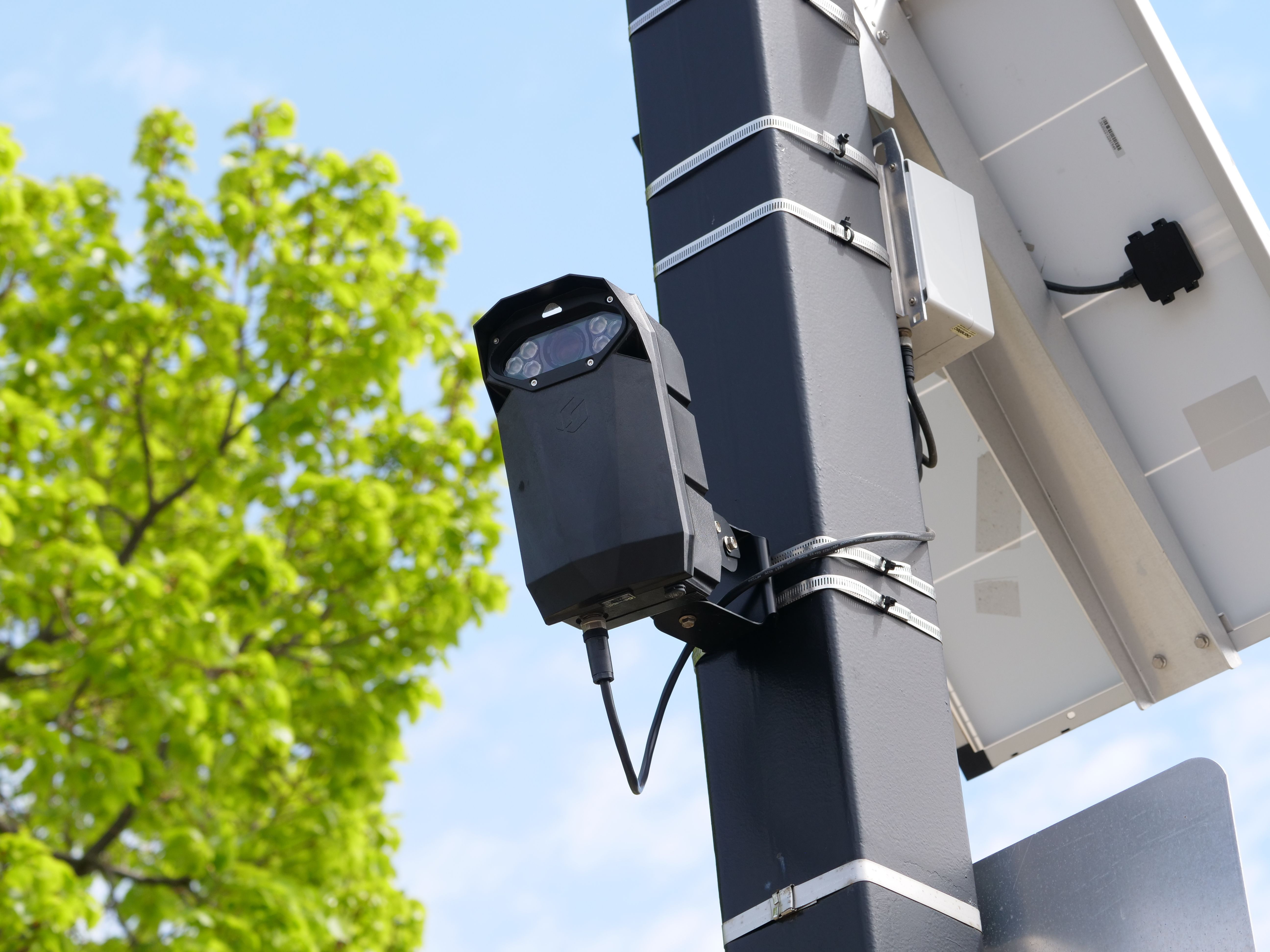 Pole-mounted license plate reader and traffic surveillance camera capturing accident security footage on a Philadelphia street.