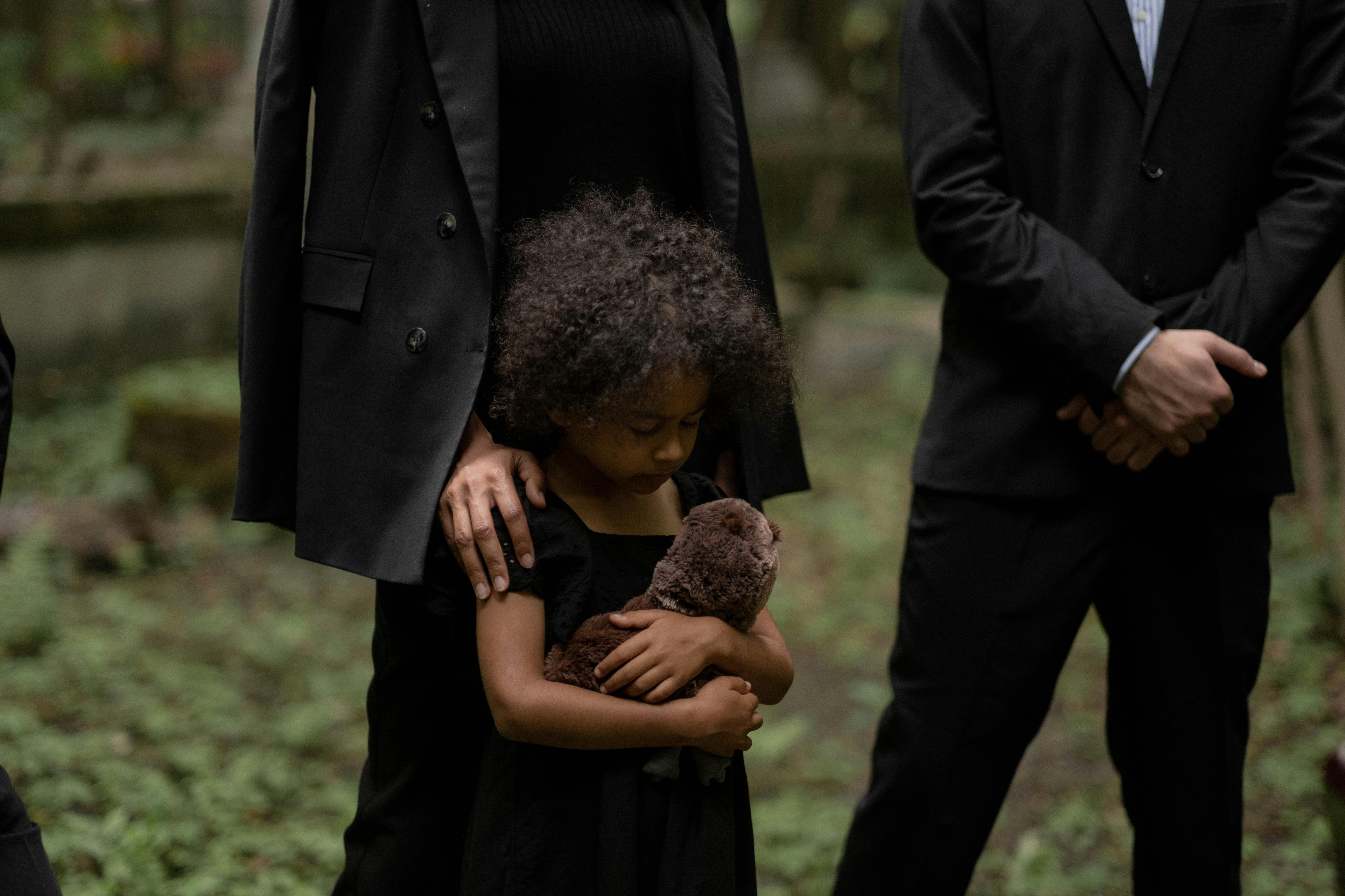 Image Grieving child holding teddy bear at funeral symbolizing emotional loss in a wrongful death lawsuit caused by negligence in Pennsylvania