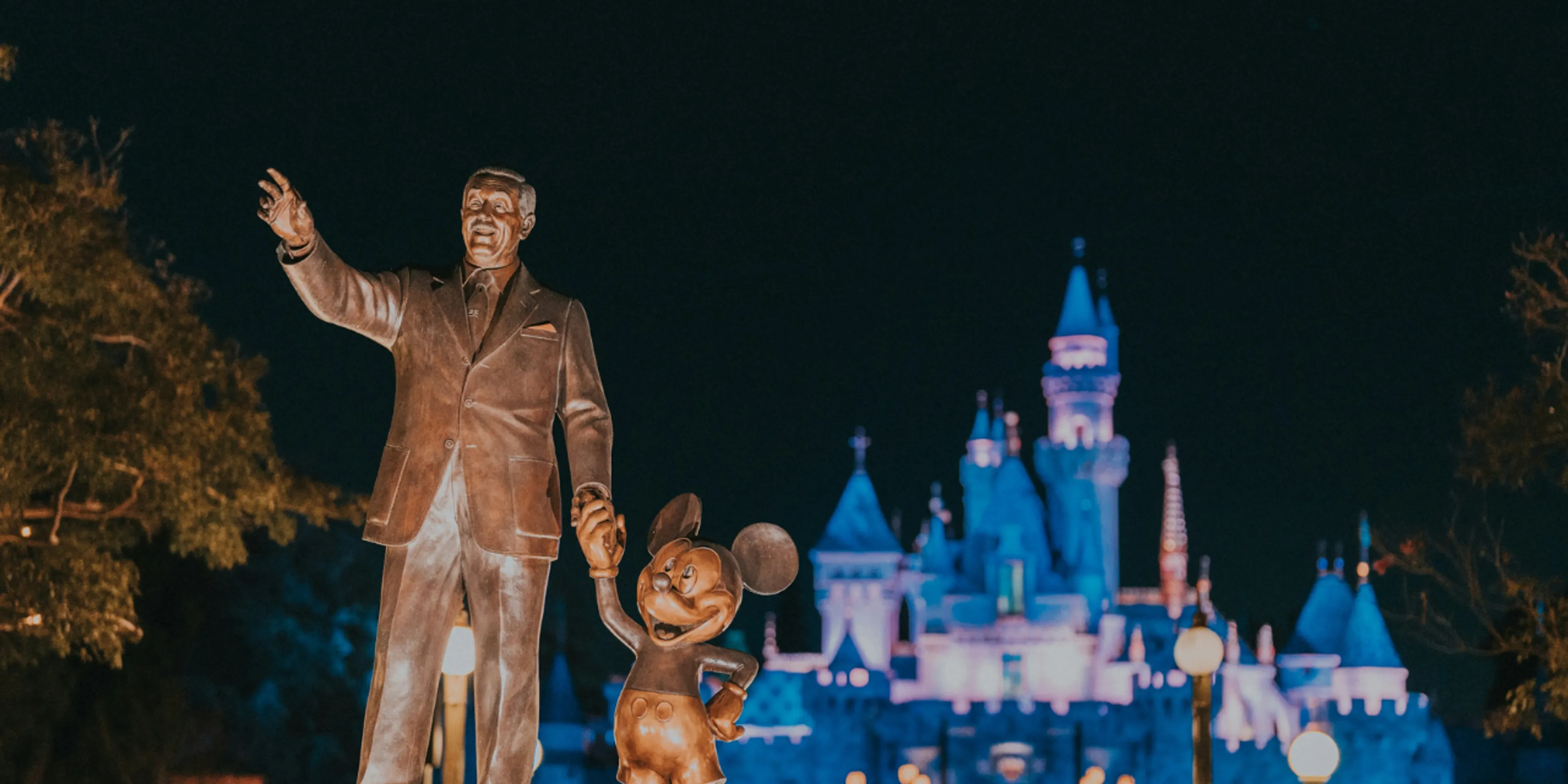 Estatua de Disney y Mickey en Disneyland de noche