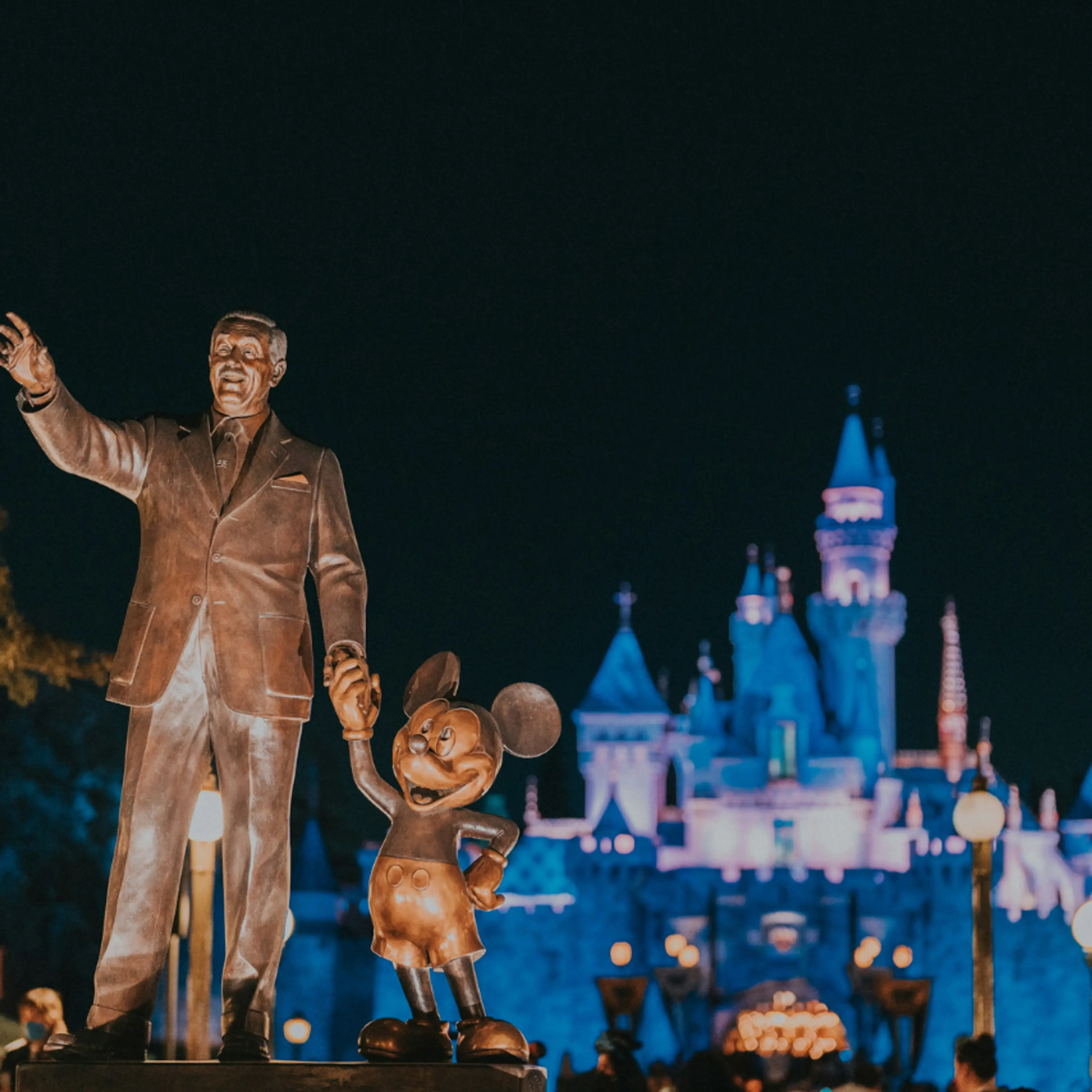 Estatua de Disney y Mickey en Disneyland de noche