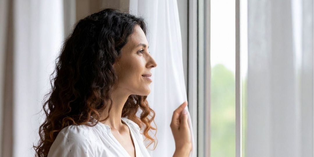 Mujer viendo por la ventana