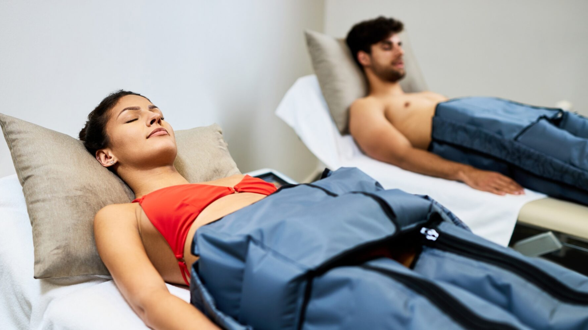 Hombre y mujer recibiendo tratamiento de presoterapia en piernas dentro de Radiance Body Lab.