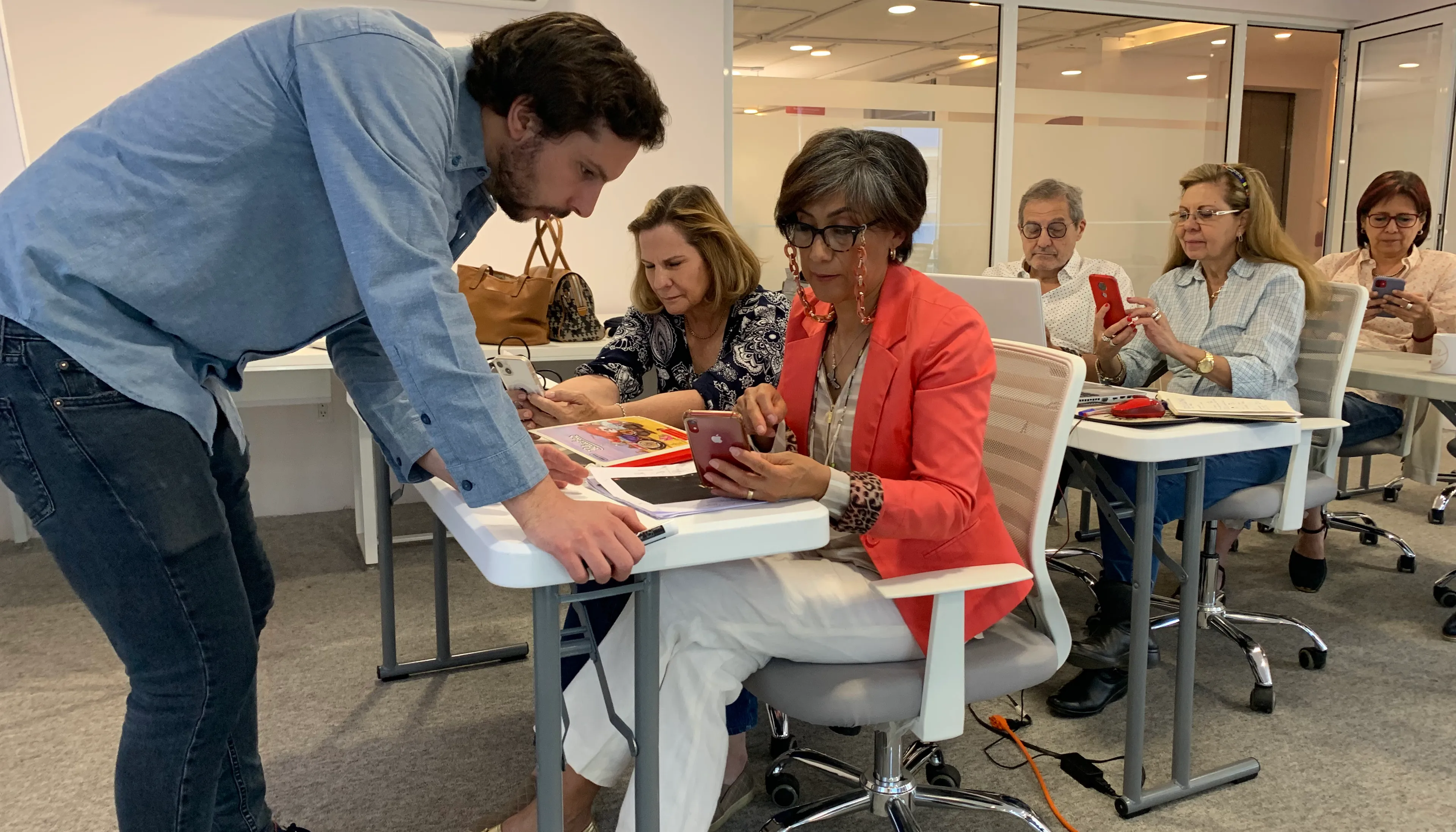 profesor enseñando a usar el celular a sus alumnos