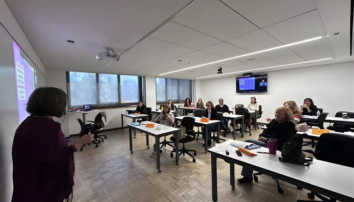 Docente impartiendo clase a grupo de adultos en aula moderna de la Universidad Anáhuac México.