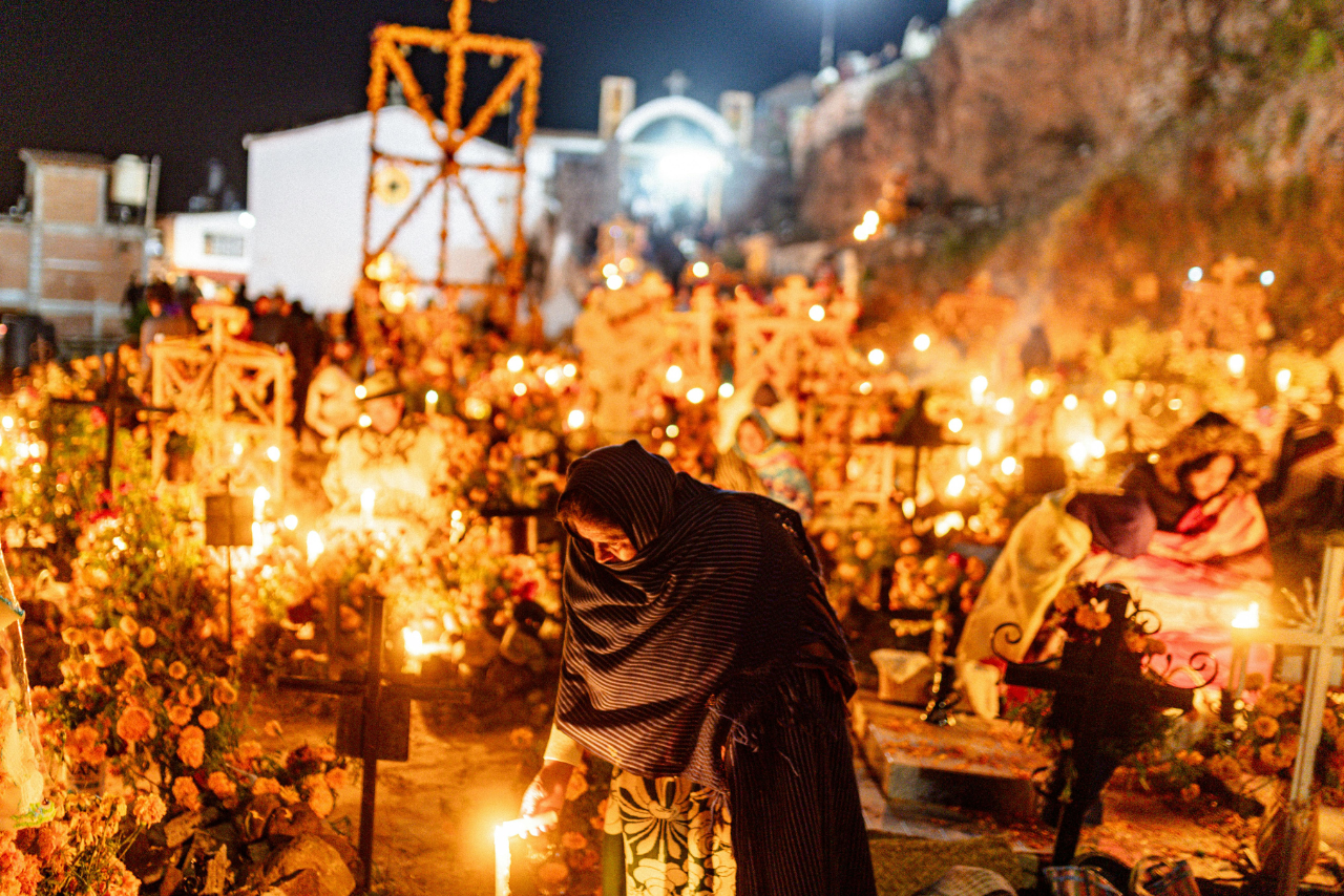 Persona en panteón Día de los Muertos