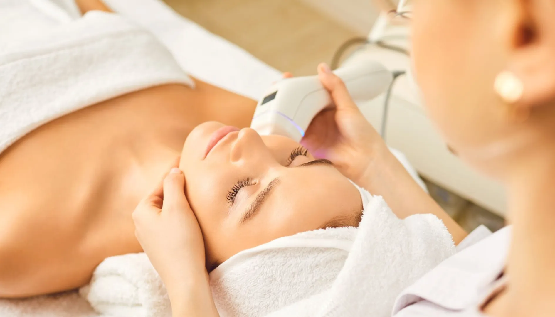 Mujer recibiendo tratamiento facial con dispositivo estético de alta tecnología en Radiance Body Lab.