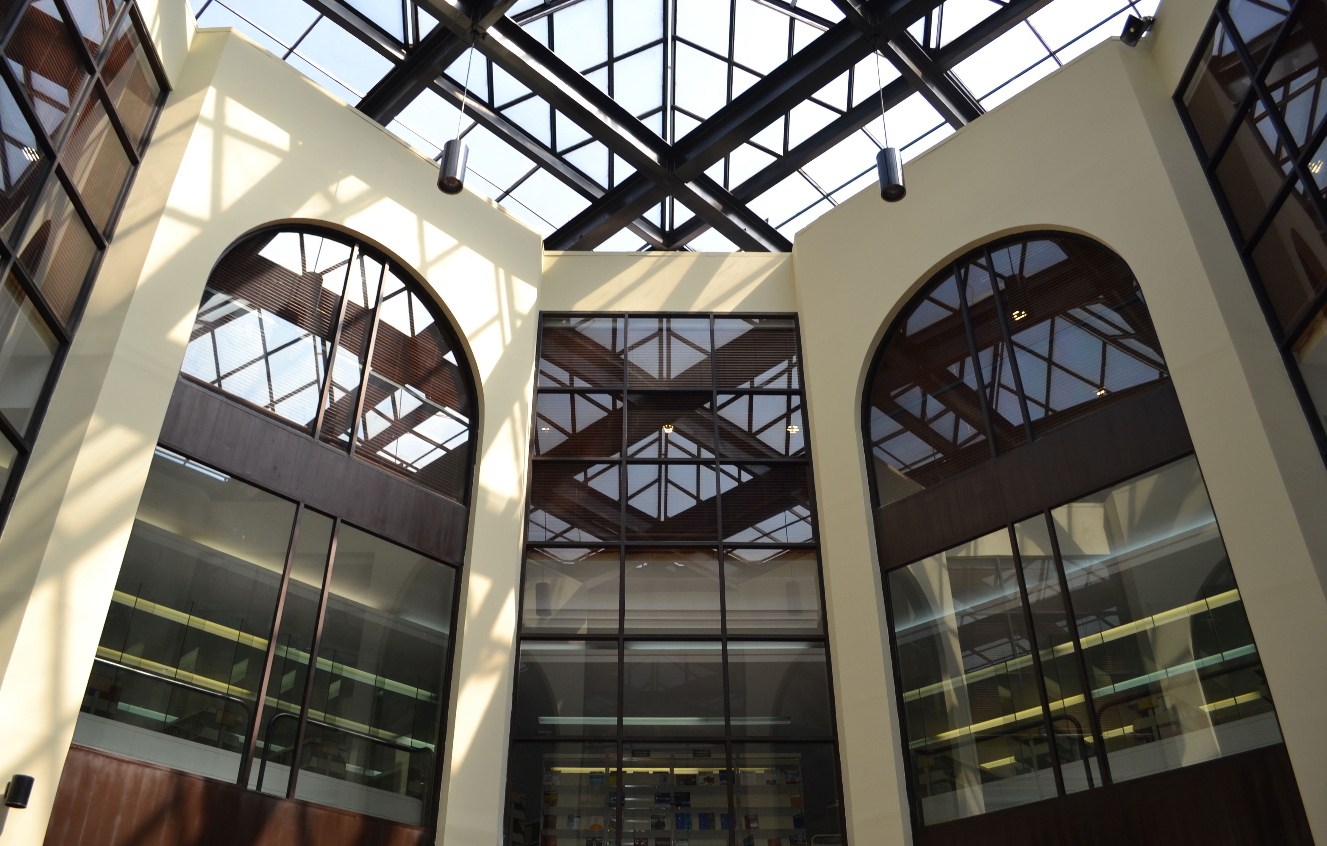 Interior del campus ITAM con estructura de vidrio y techos altos, destacando diseño arquitectónico contemporáneo y ambiente académico.