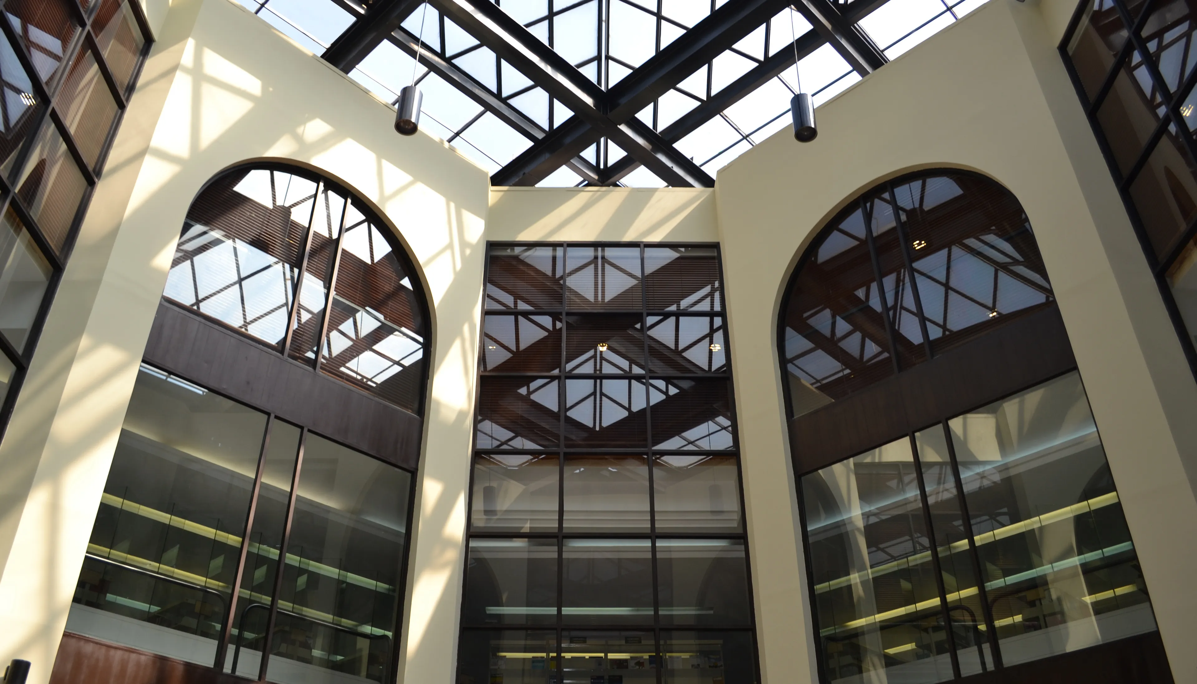 Interior del campus ITAM con estructura de vidrio y techos altos, destacando diseño arquitectónico contemporáneo y ambiente académico.