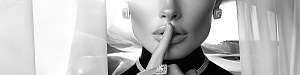 A woman, elegantly draped in exquisite jewelry, places her finger to her lips in the timeless gesture of safeguarding a secret.