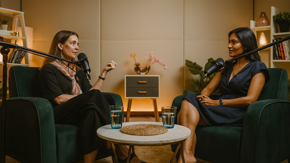 Two women record a podcast in a cozy, production-ready studio with velvet armchairs, ambient lighting, and professional microphones — ideal for creators booking podcast studios in Bangalore, Mumbai, or Delhi via BOOKD.