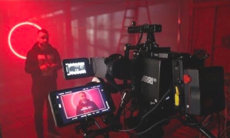 Behind-the-scenes of a cinematic shoot in a red-lit studio using ARRI camera gear, with a subject framed on monitor — ideal for music videos, ad films, and branded content productions in BOOKD-listed studios across India.