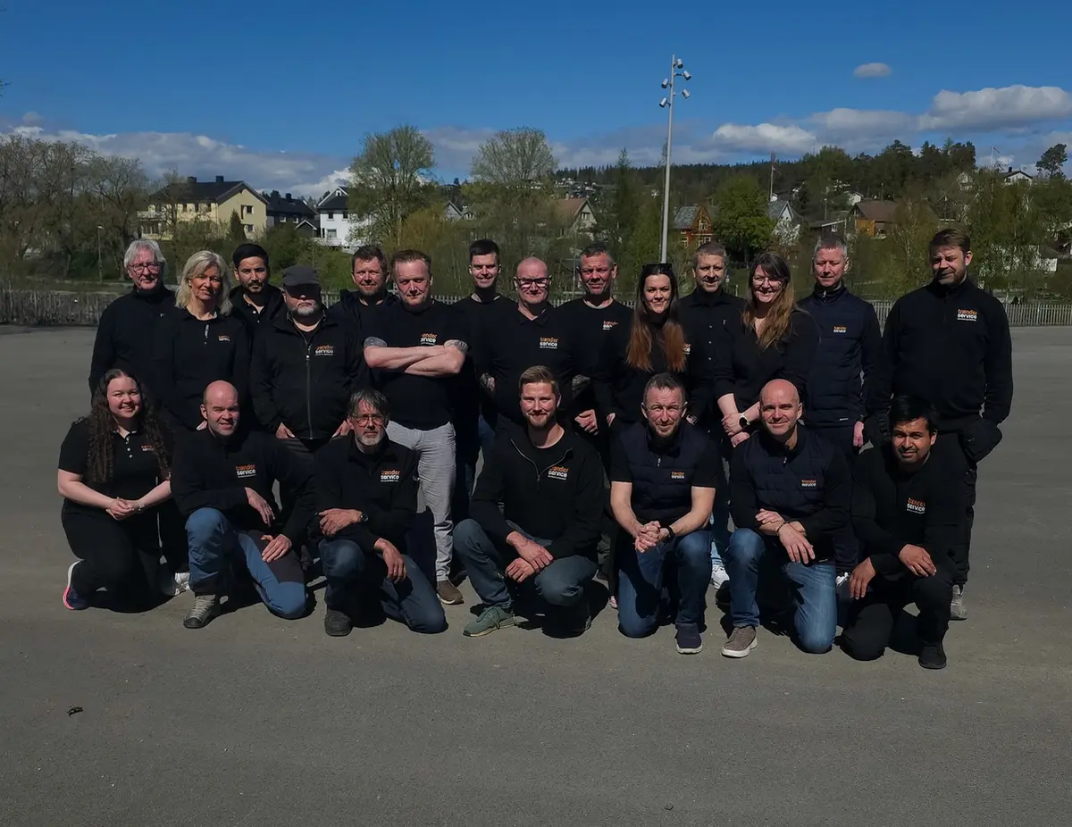 Hele teamet i Trønderservice AS samlet utenfor verkstedet med servicebilene
