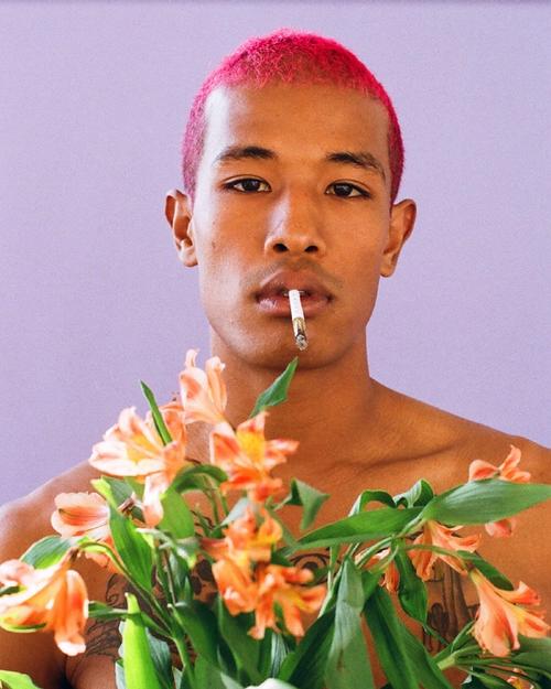 man posing with joint and flowers