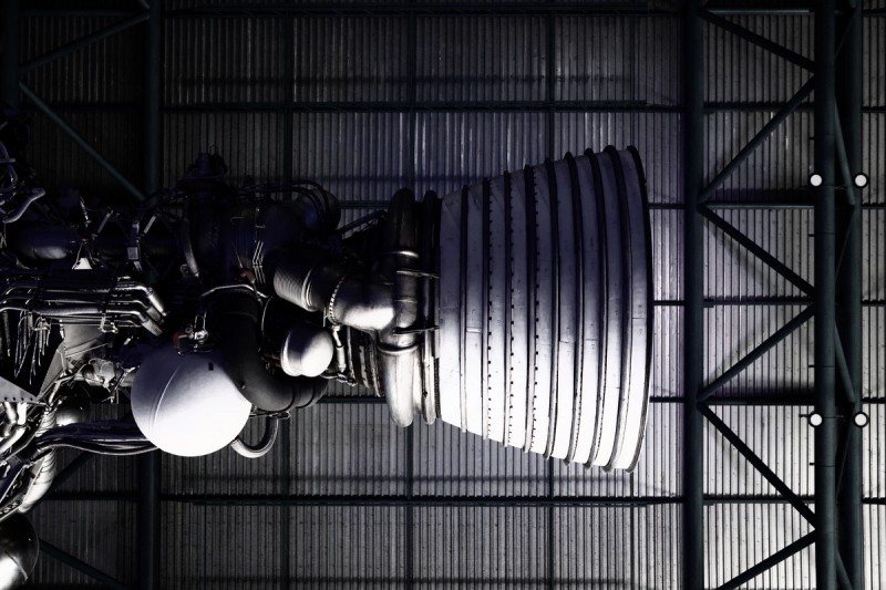 Rocket booster viewed from below with metal hanger ceiling above