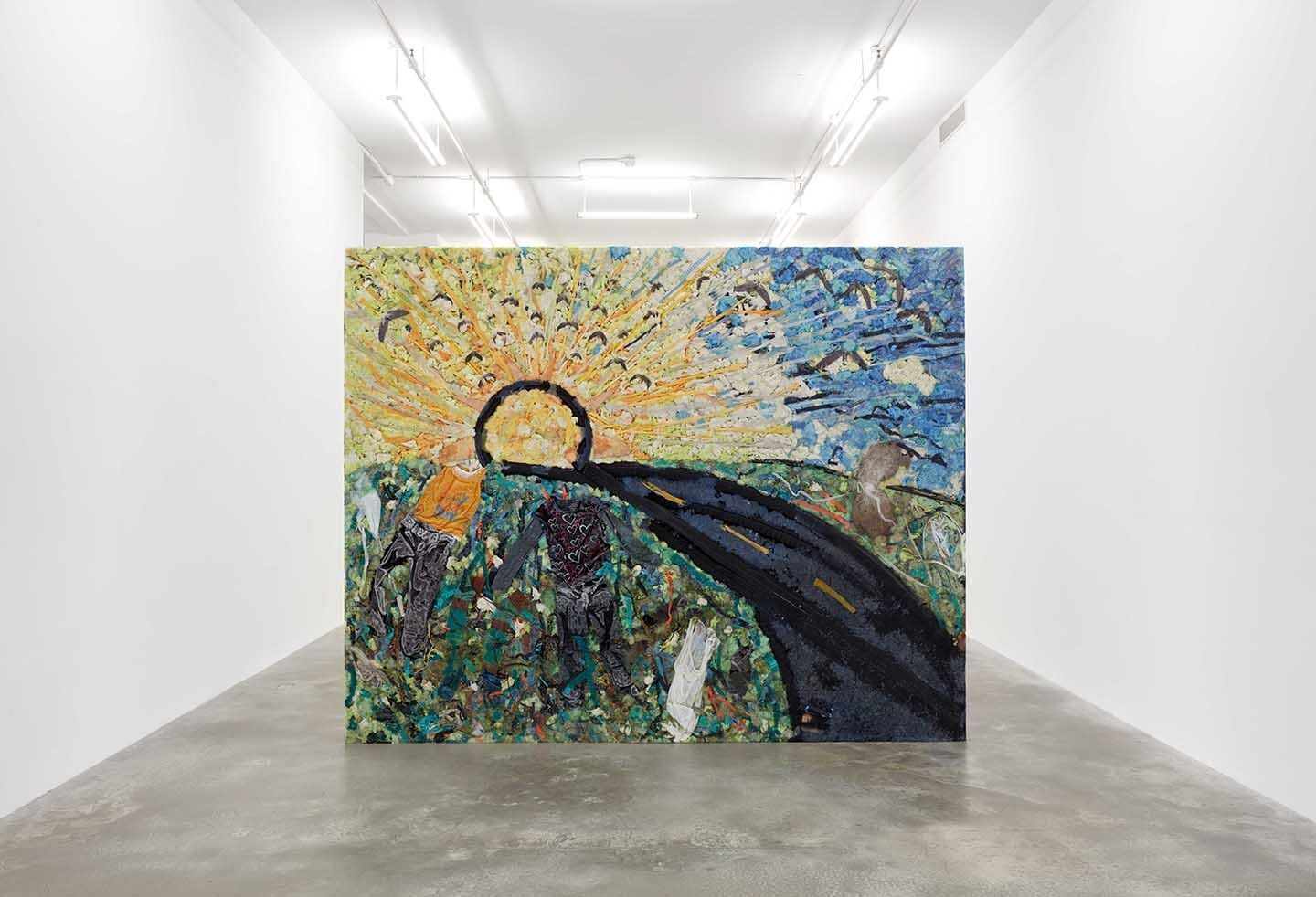 A flat sculpture depicting a sun, sky, and roadway