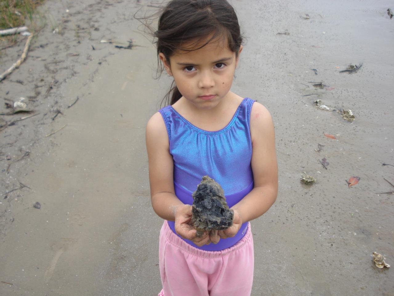 Bastida, age 4, holding sand contaminated with crude oil from an oil spill off the coast of Veracruz, Mexico. (Courtesy Xiye Bastida)