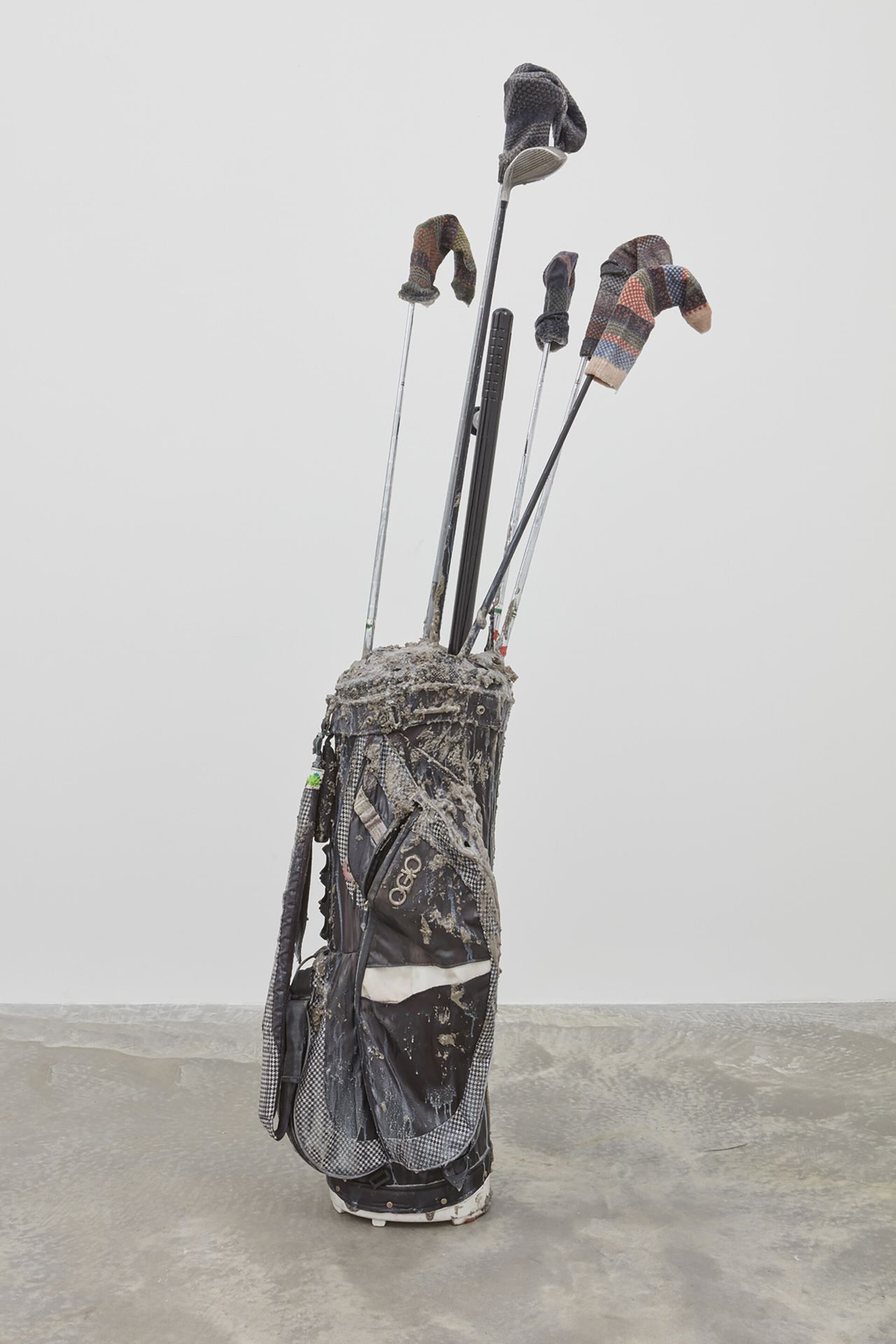 A bag of golf clubs and golf irons in a gallery