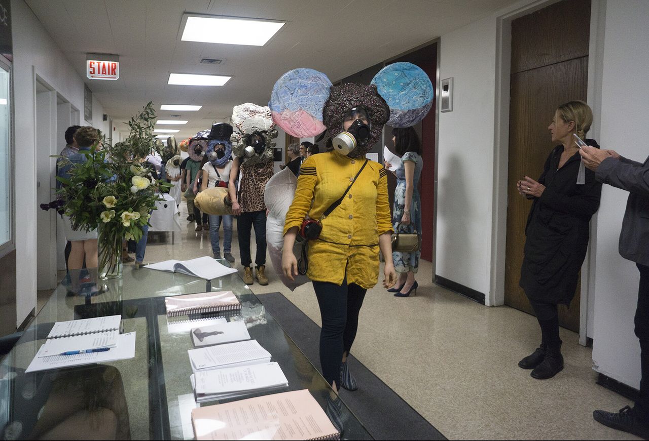People in masks walking through a hallway